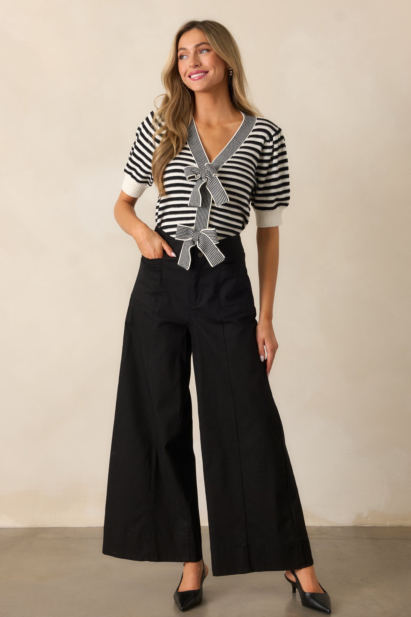 Another full-length view of the black pants showcasing the high-rise fit, smooth fabric, and flowy wide-leg style.