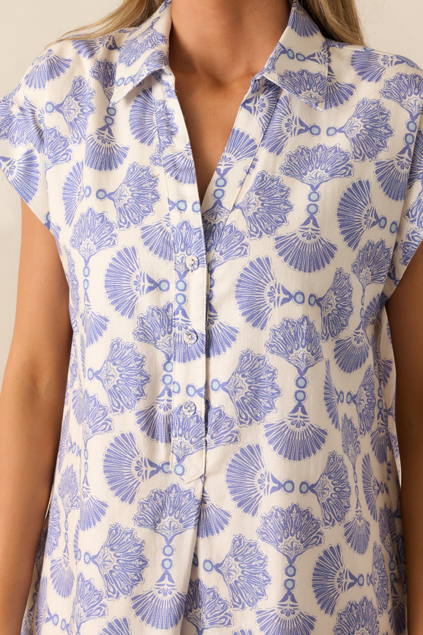 Close-up of the collared V-neck neckline and cap sleeve detailing of the Dusty Blue mini dress.