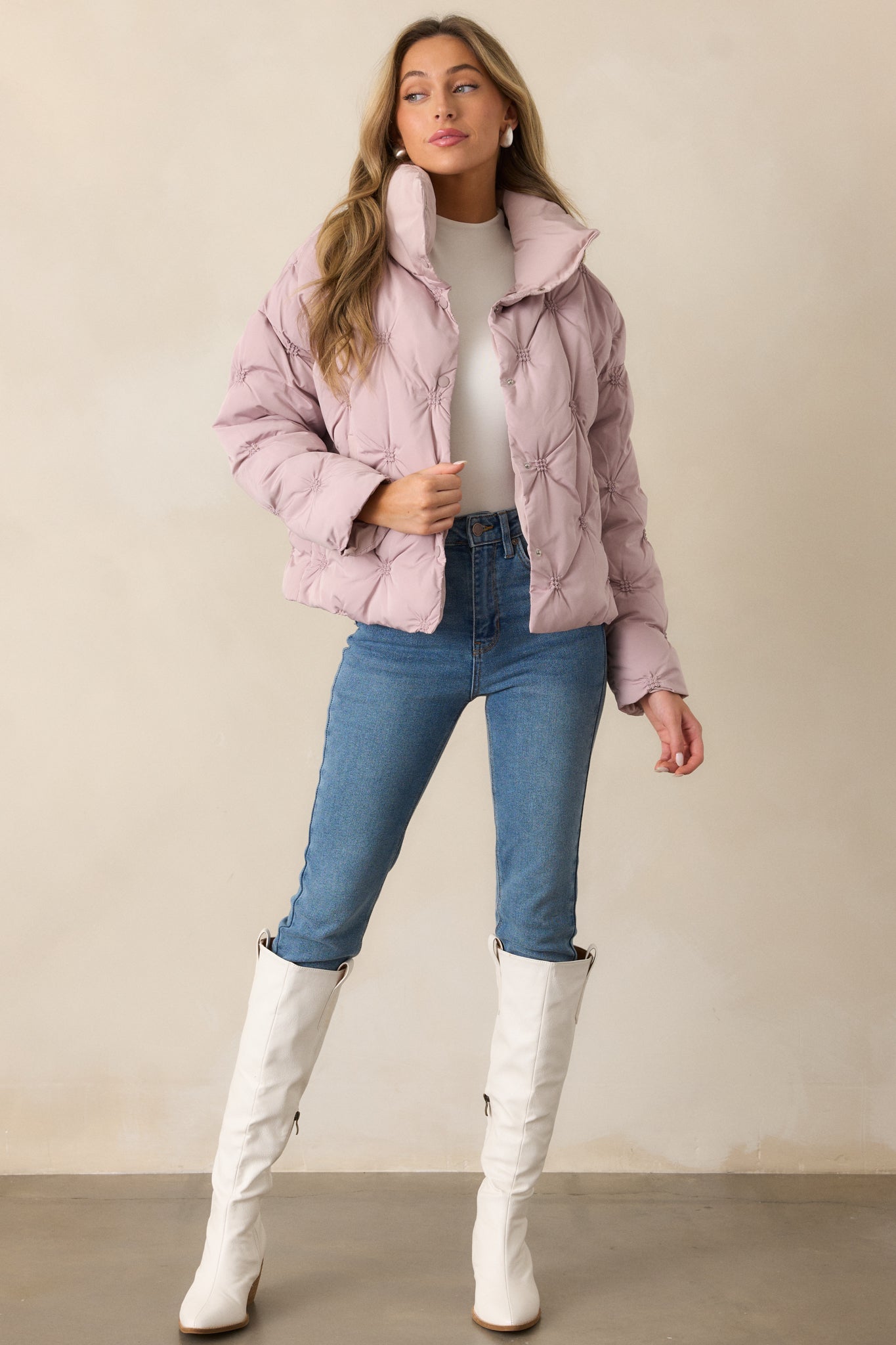 A mauve jacket with a high collared neckline, snap button front, and tufted detailing, shown in a full-length view.