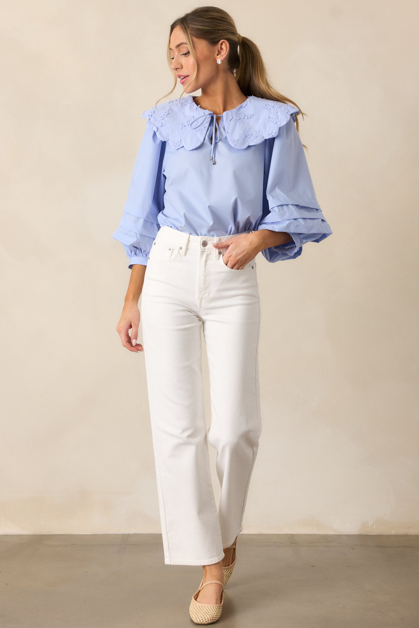 A front-facing shot of the white jeans, emphasizing the high-waisted fit, the clean lines of the straight leg cut, and the functional pockets on both the front and back.