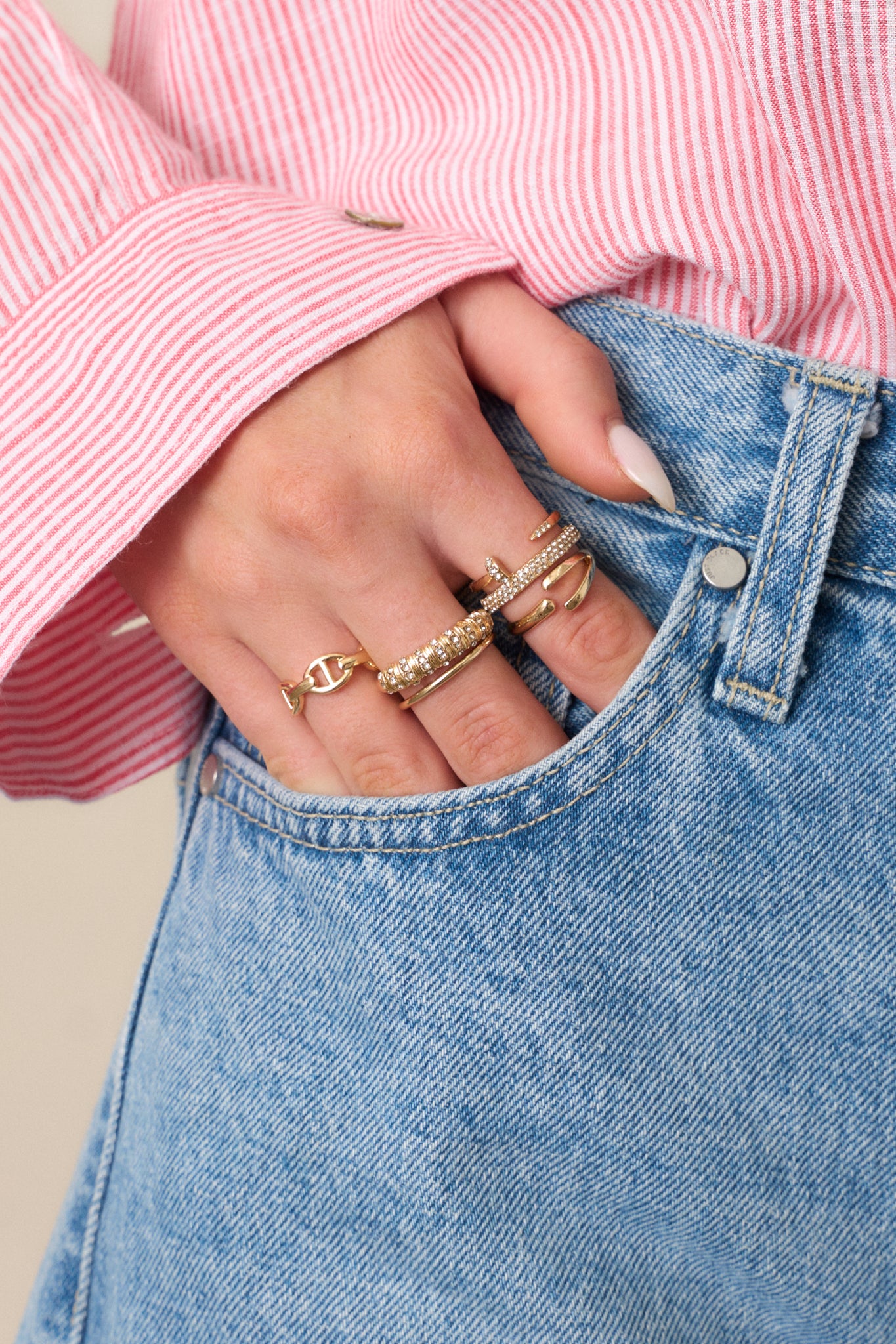 A close-up shot of the gold ring stack, highlighting the intricate designs of the adjustable gold rings with circular decorations and rhinestone pave detailing, as well as the wishbone and thick gold pave rhinestone rings.