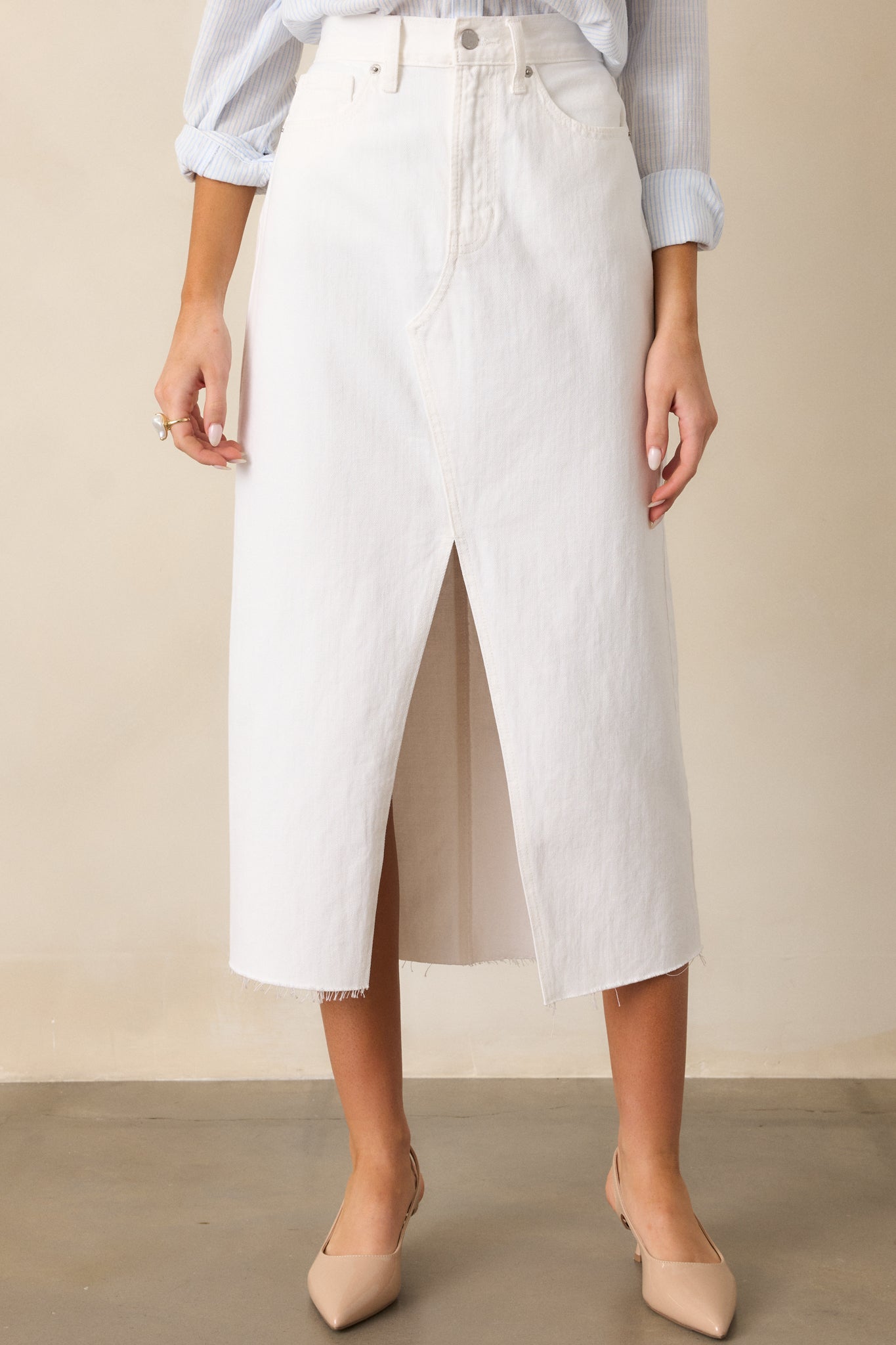  close view of the white skirt highlighting the front slit, functional belt loops, and smooth fabric.