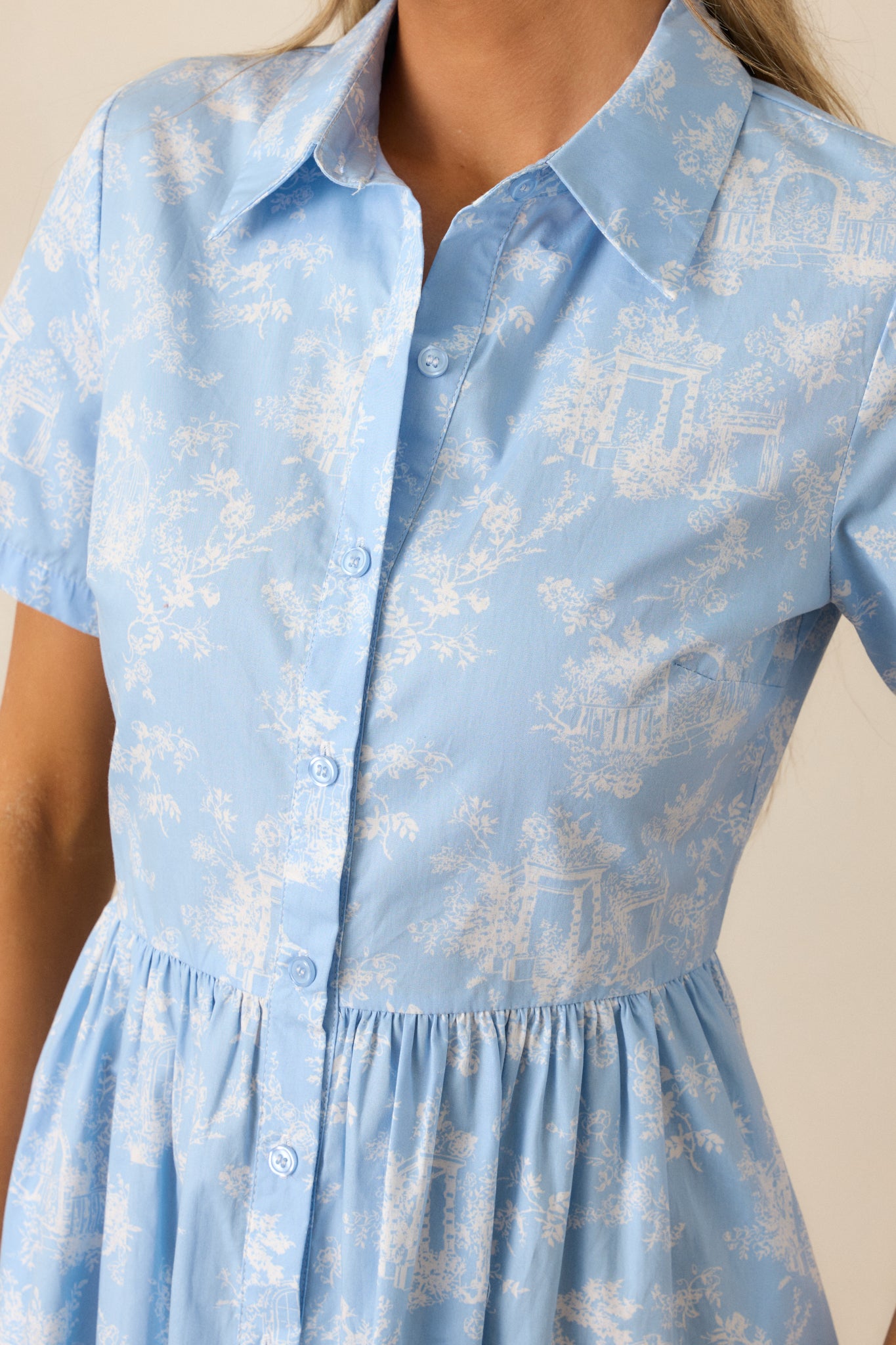 A close-up of the light blue maxi dress showing the button front, collared neckline, and fine toile pattern.