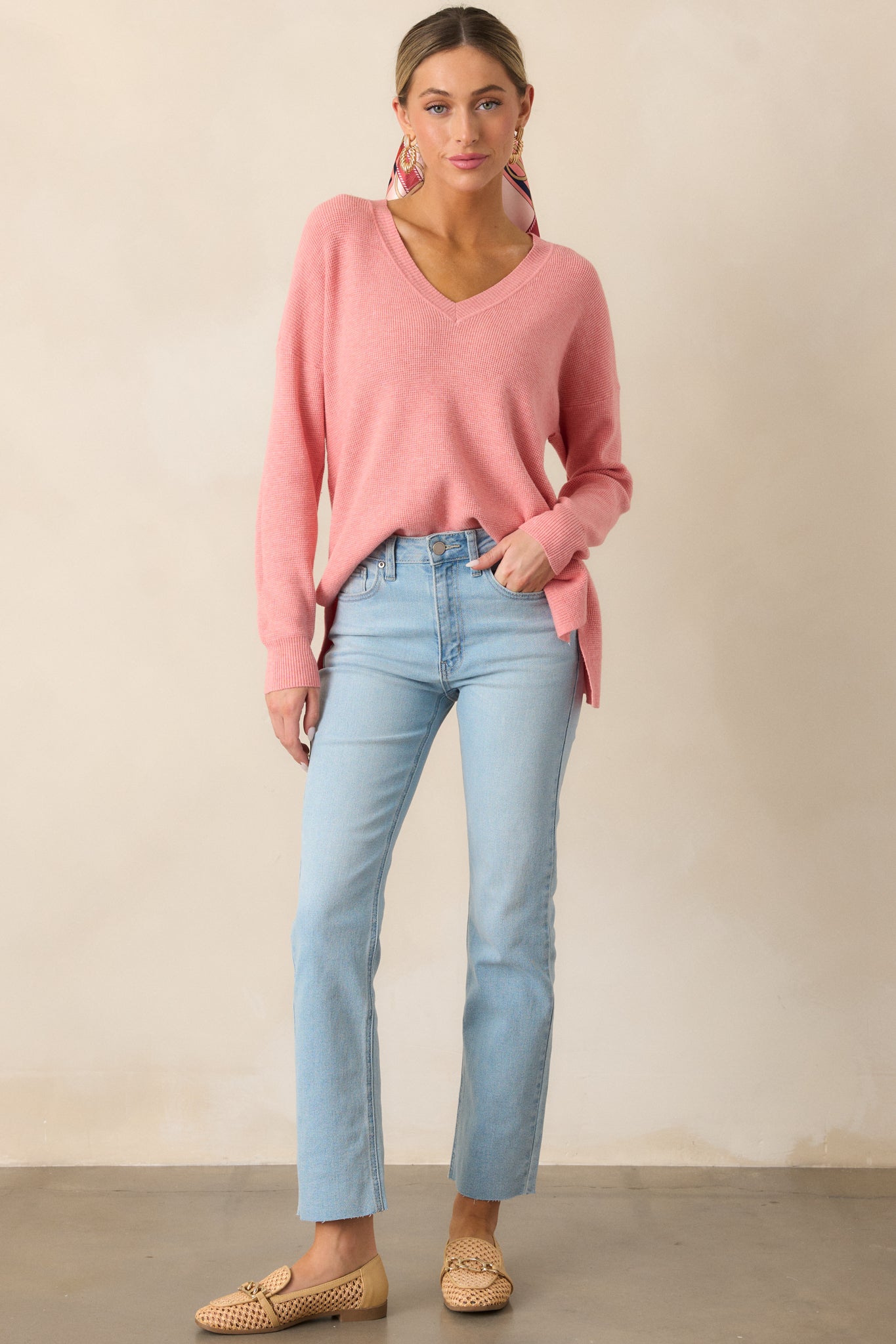 The rose sweater showcases a flattering v-neckline, relaxed fit, and split hem bottom, paired with ribbed cuffs for a snug finish