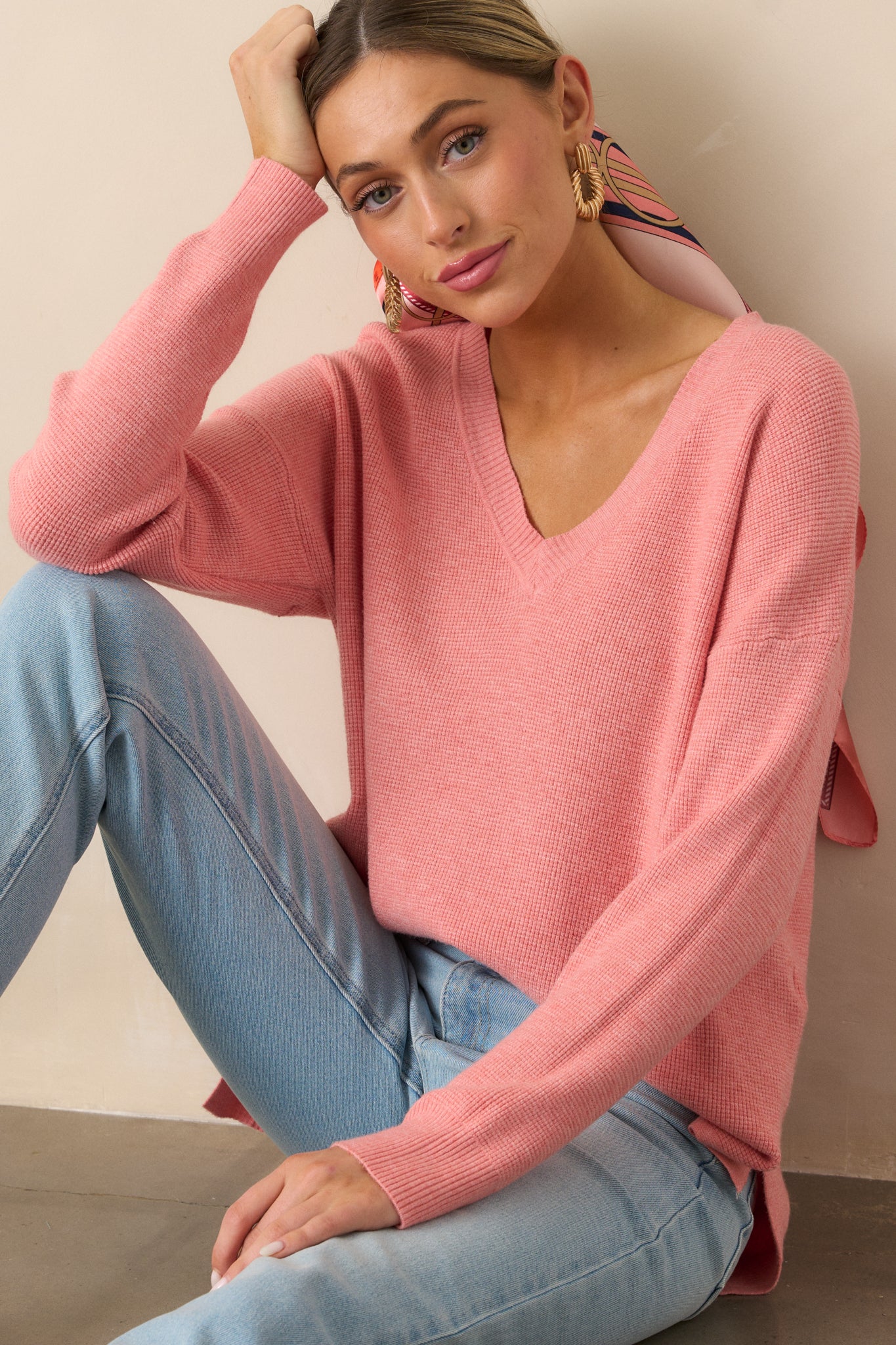 This rose sweater features long sleeves with rib cuffs, a v-neckline, and a relaxed fit, with a split hem that adds a modern twist.