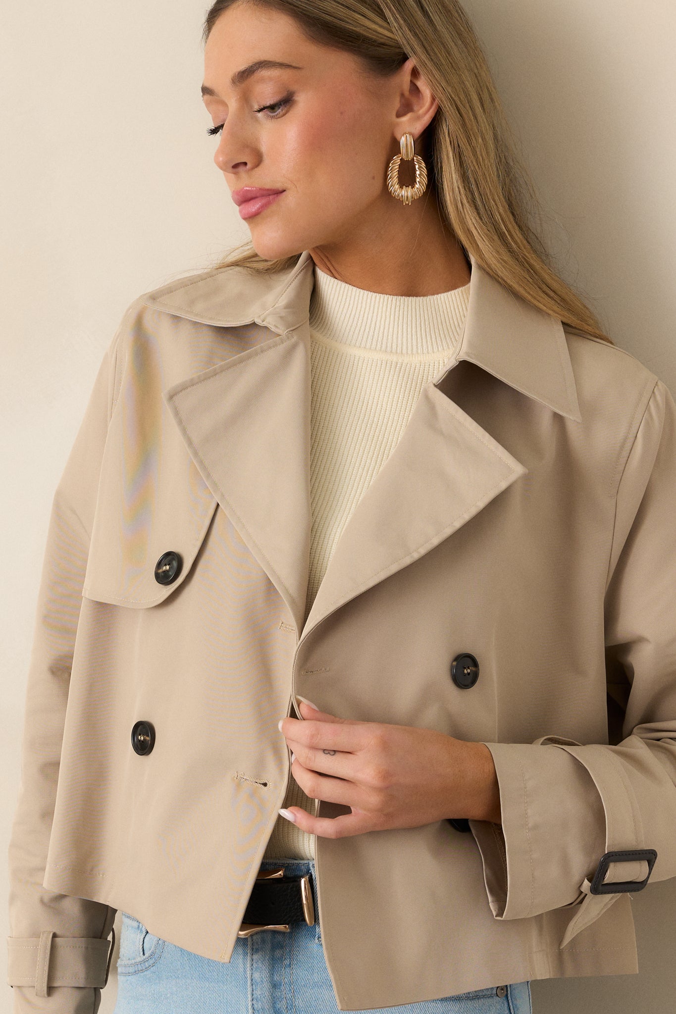 A detailed look at the long sleeves of the khaki coat, showcasing the buckle accents for a touch of added style.