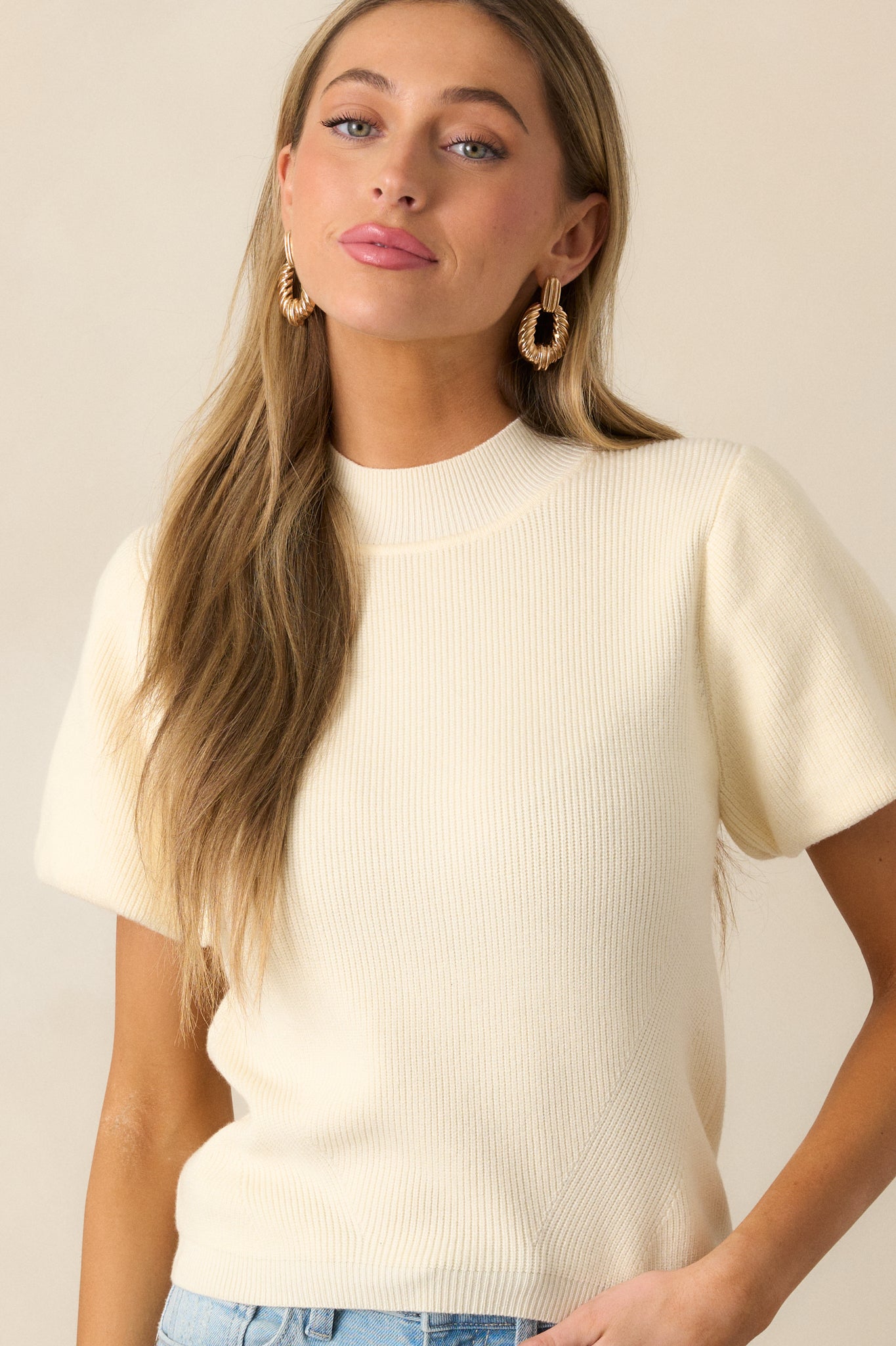 The knit design of the ivory top is emphasized, showcasing the mock neckline and short puff sleeves for a fresh, airy vibe.