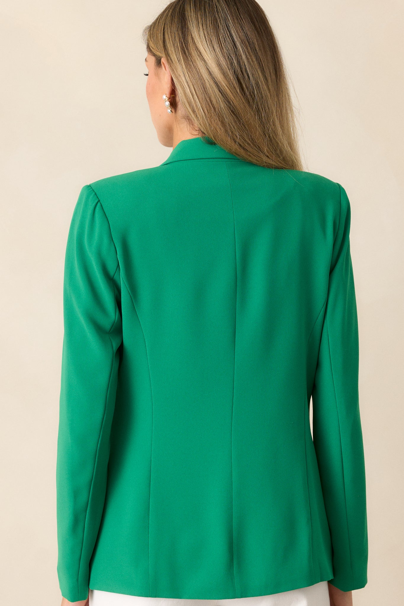 Back view of the green blazer, highlighting the tailored fit, long sleeves, and clean, seamless design.