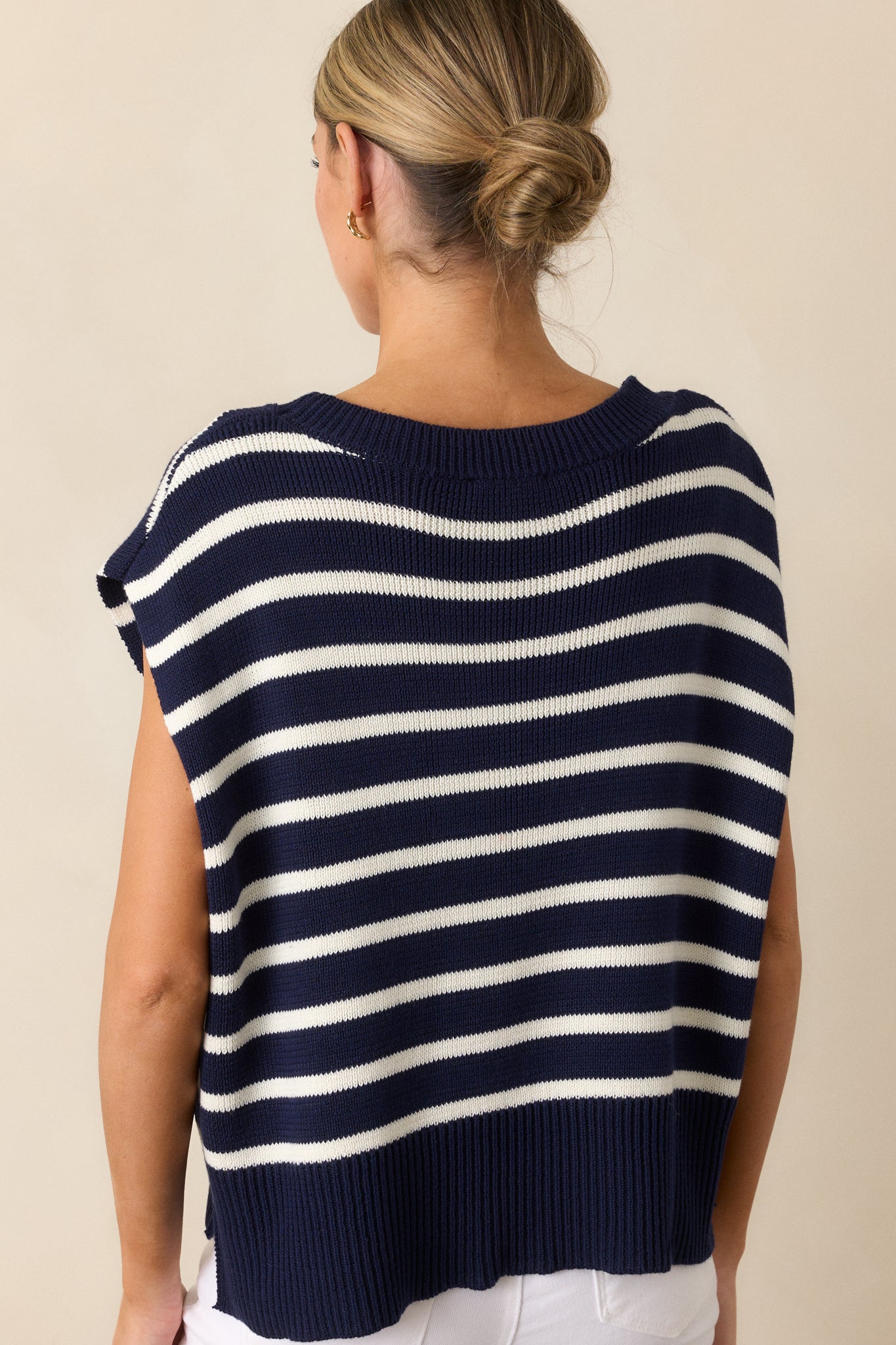 Back view of the navy sweater top, featuring its horizontal stripe design and short sleeves.