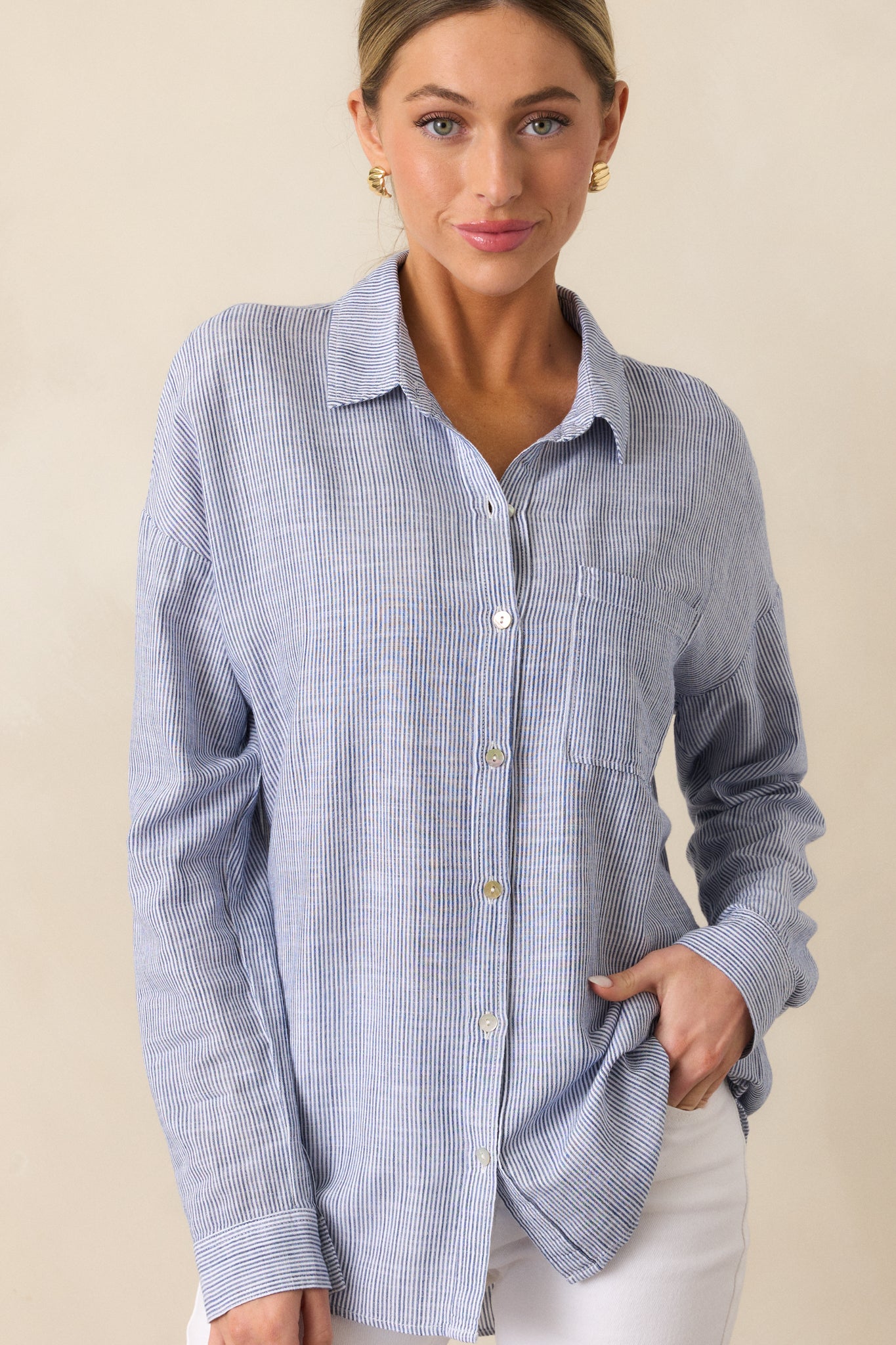 A cropped shot highlighting the collared neckline and button front design, with the front pocket and sleeve cuffs visible.