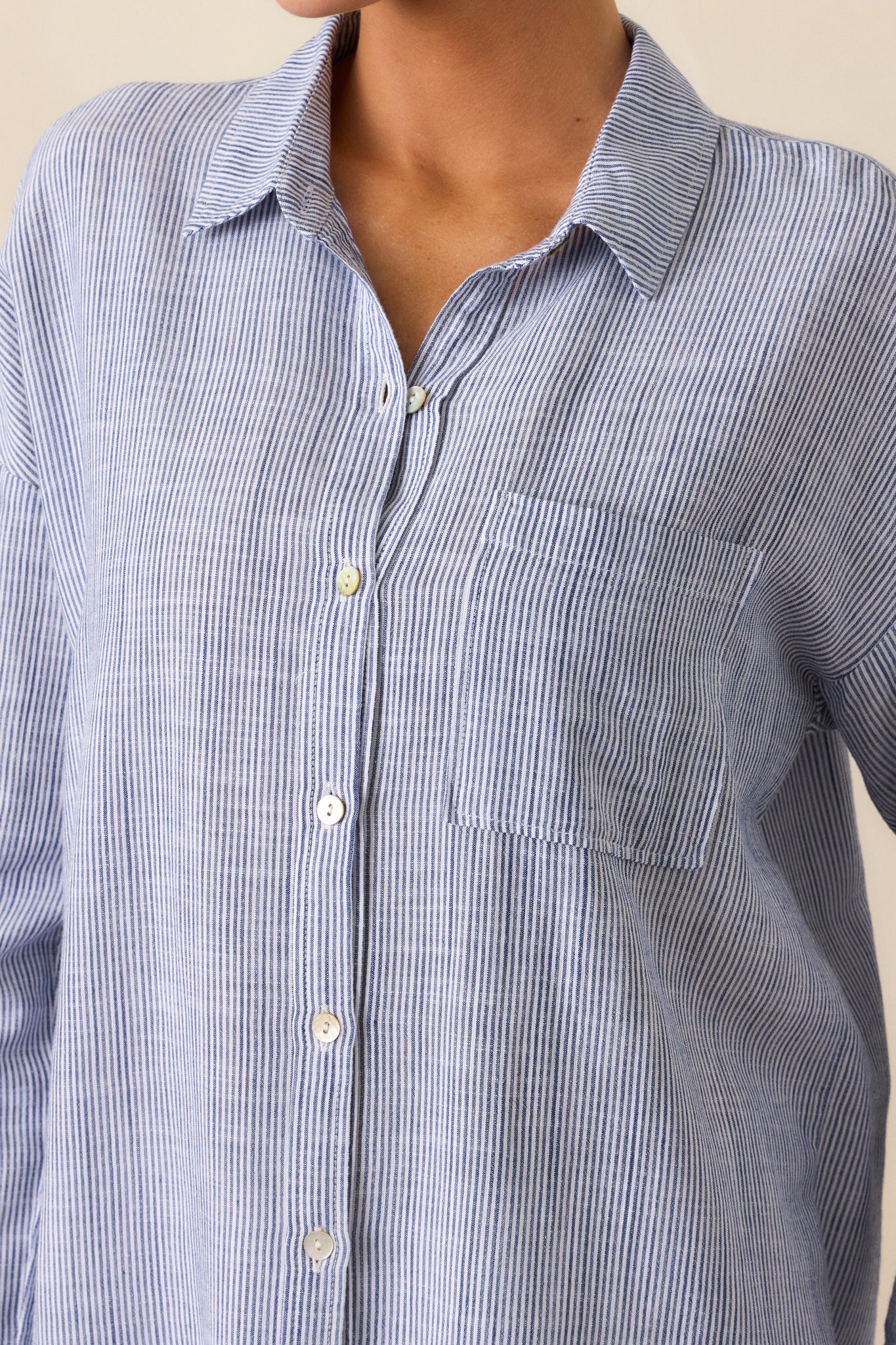 A close-up of the button front design and front pocket, showcasing the blue  blouse’s soft material and functional buttons.