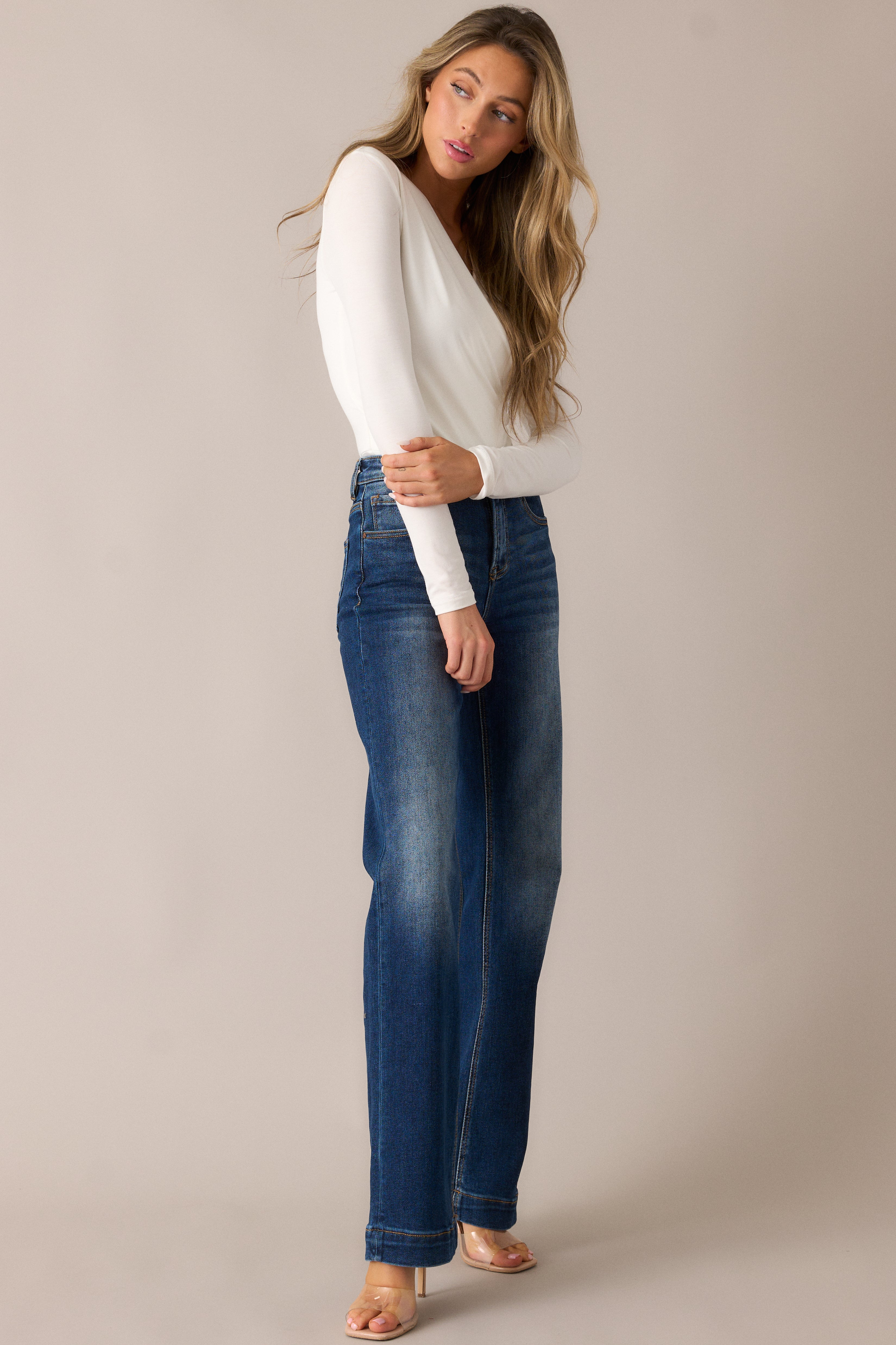 Sleek dark wash jeans with a high-waisted design, functional belt loops, and a straight leg cut, featuring subtle faded detailing on the thighs and knees for a worn-in, stylish look.