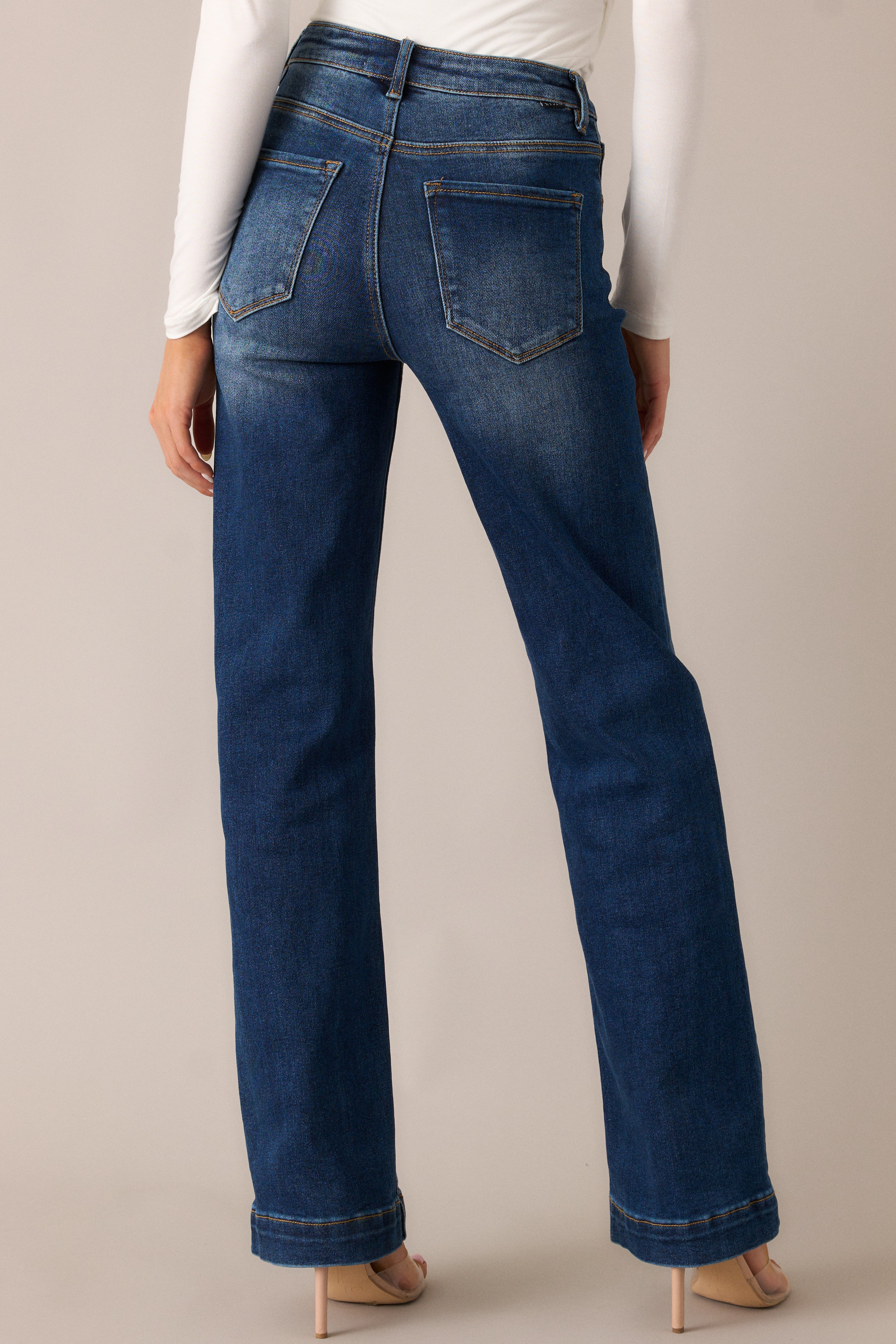 The dark wash jeans from the back, showing off the high waist, functional back pockets, and the straight leg cut, all enhanced by the subtle faded detail for a modern, flattering look.