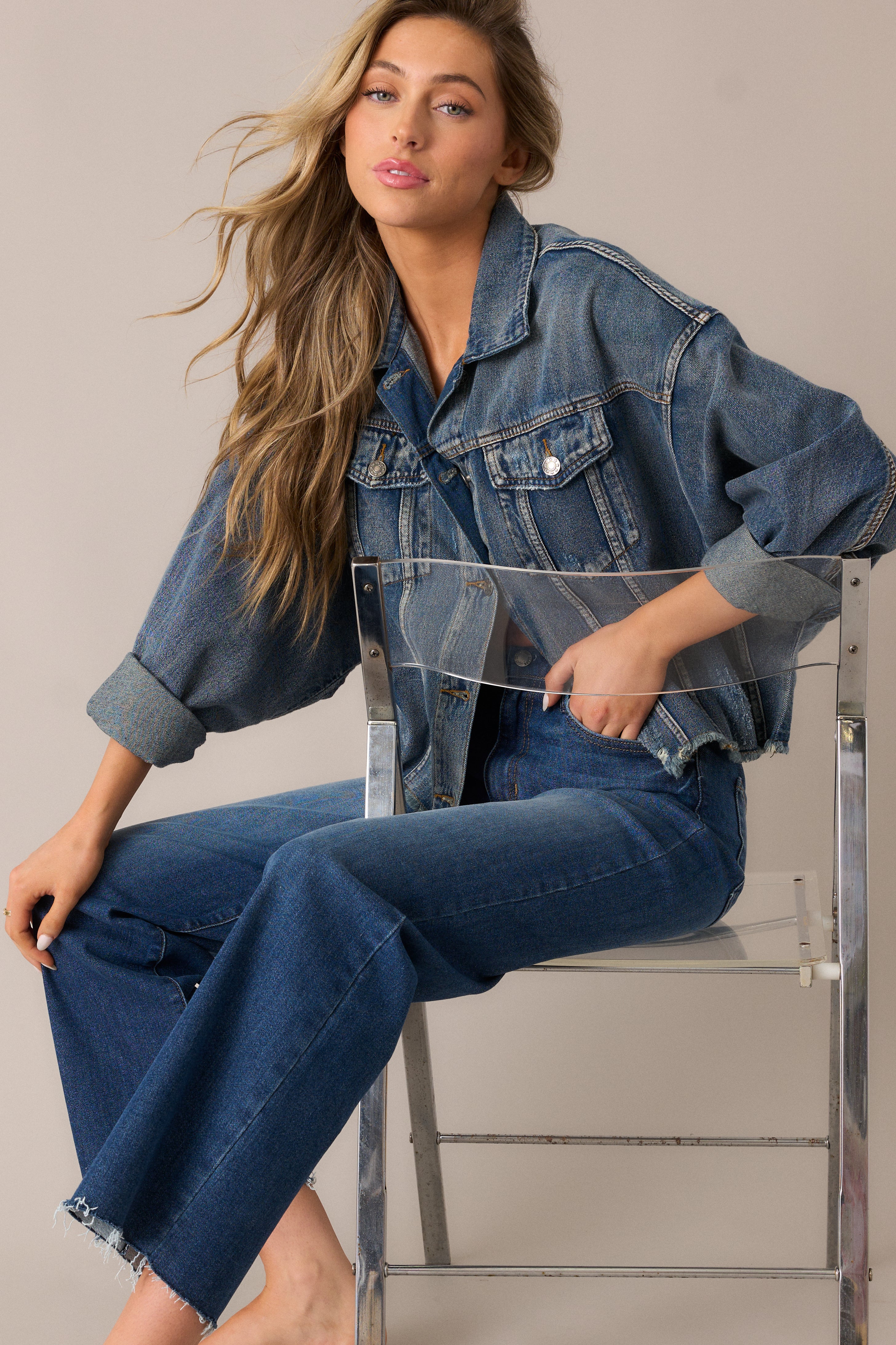 Button-front denim jacket showcasing its slightly oversized dolman sleeves, distressed accents, and functional chest pockets.