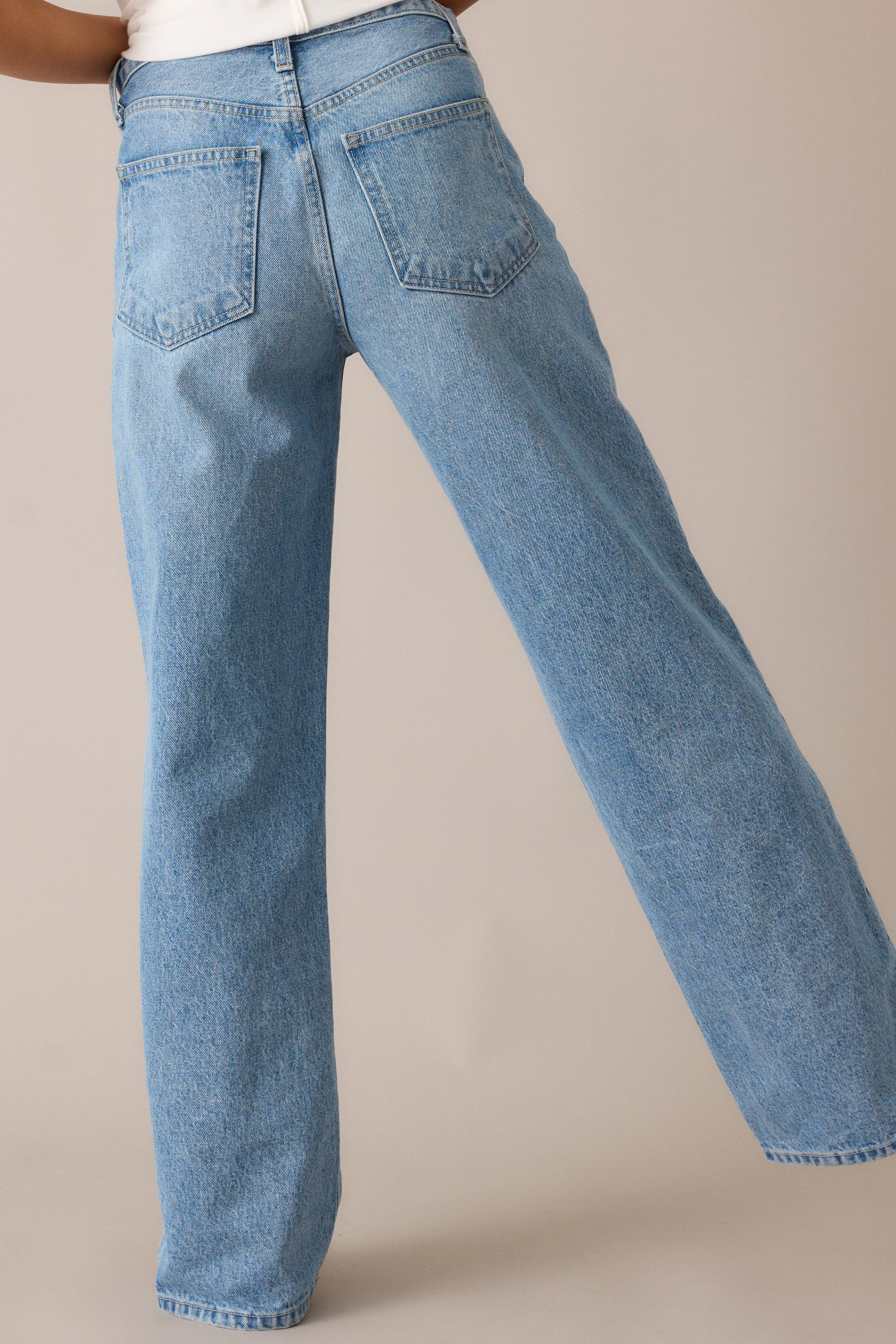 The light wash jeans from the back, showing off the high-waisted design and straight-leg cut, with a clean, smooth finish that adds to their relaxed, easygoing style.