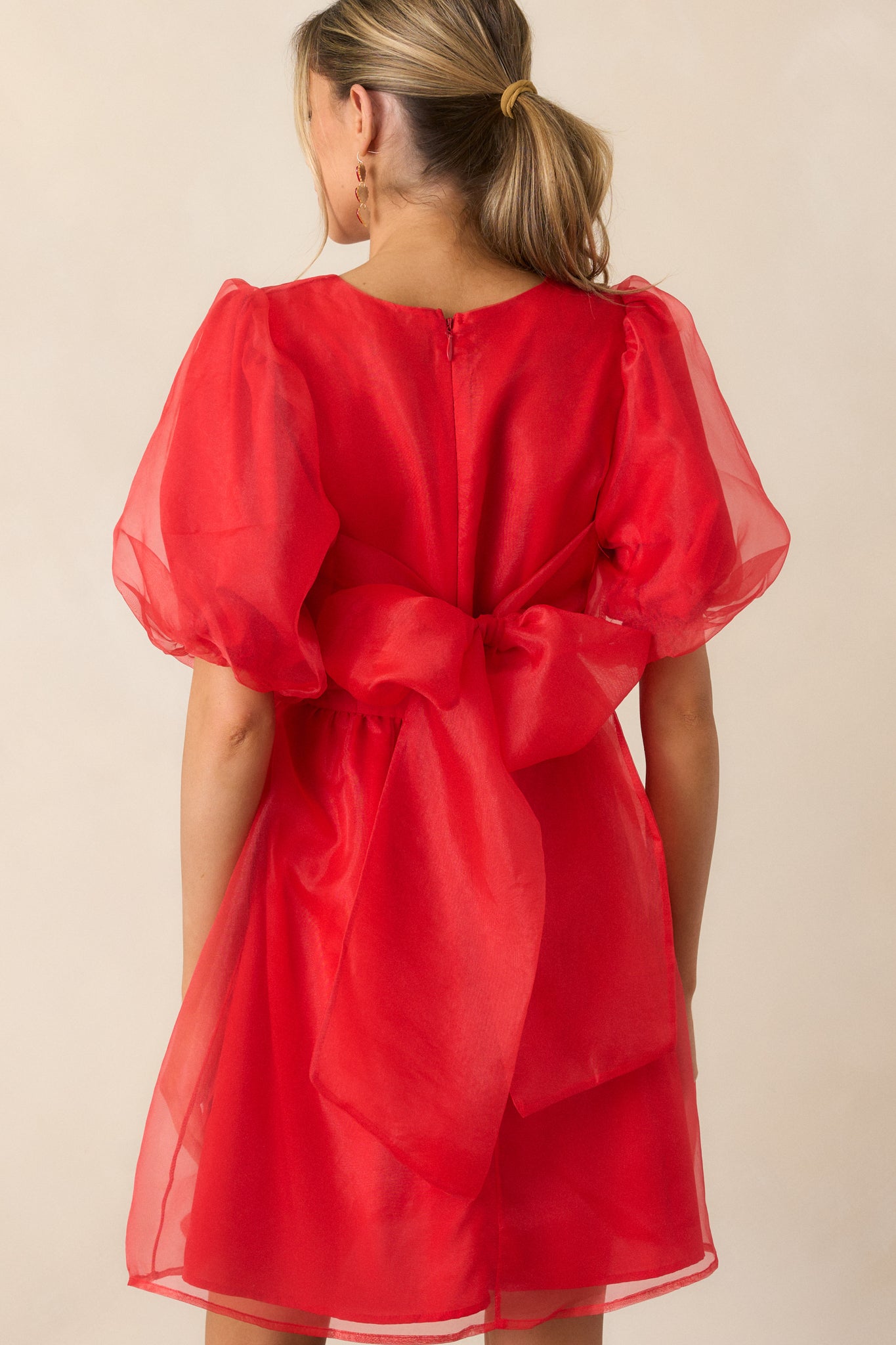 Full back view of the red mini dress, showing the self-tie organza detail and the zipper placement.