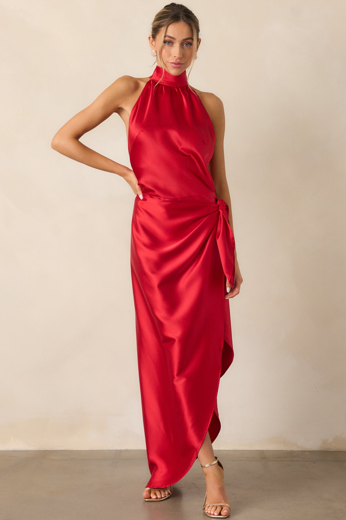 A complete look of the red dress emphasizing the wrap design and the flow of the skirt.