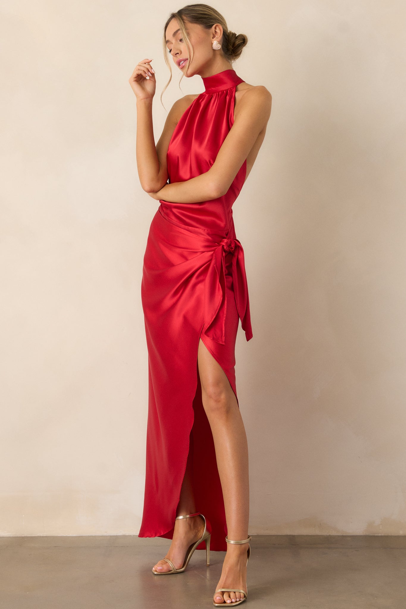 A side view of the red dress, emphasizing the adjustable straps, elegant leg slit, and the self-tie detail on the wrap skirt.