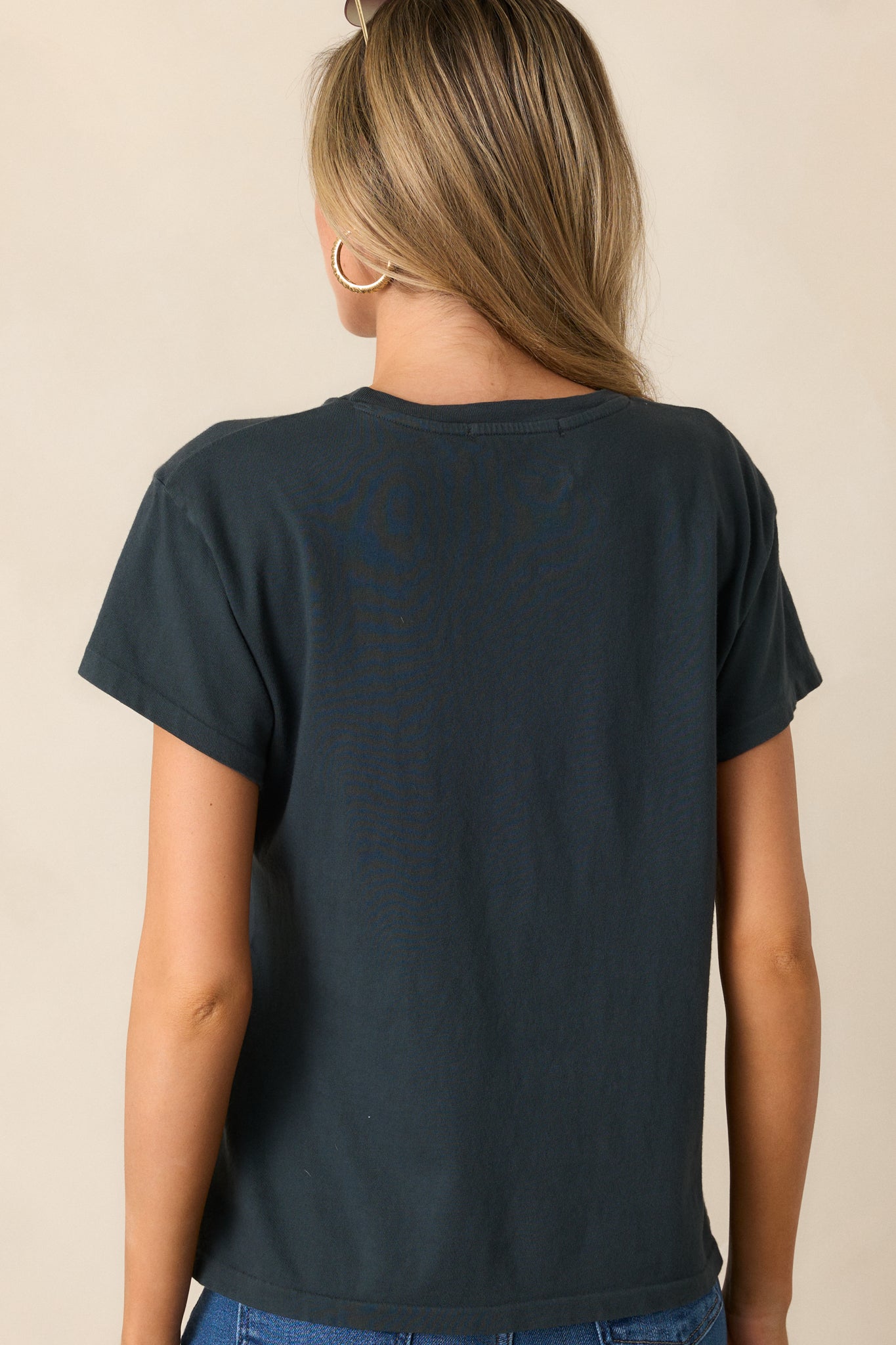 Back view of the vintage black tee, showing its plain design with short sleeves and smooth fabric finish.