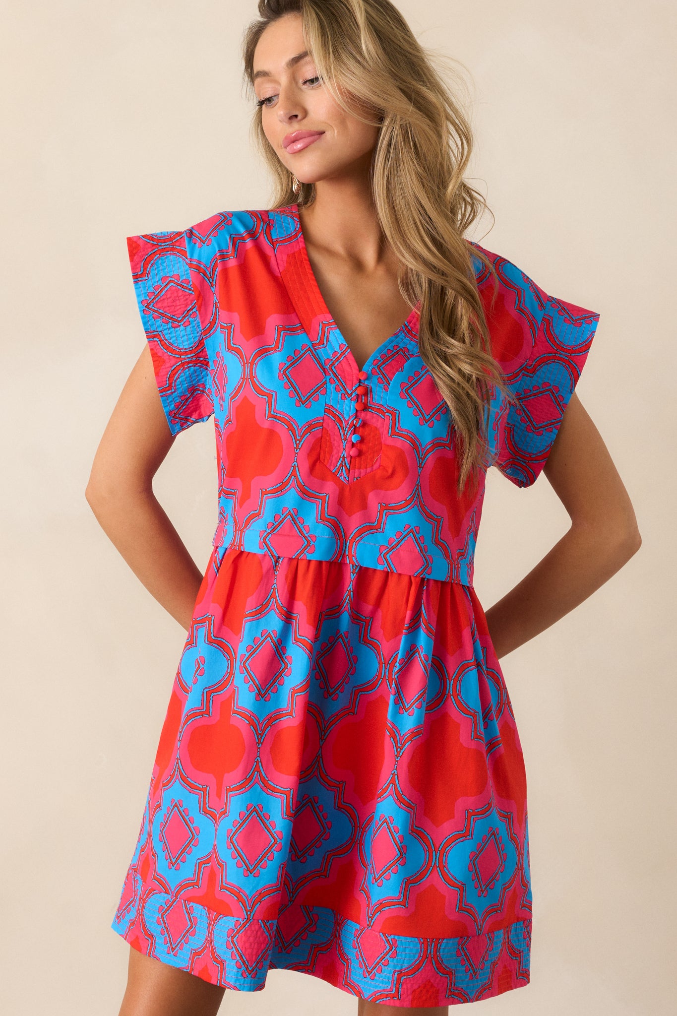 A closer look at the top of the dress, focusing on the v-neckline and the intricate pink and blue print on the fabric