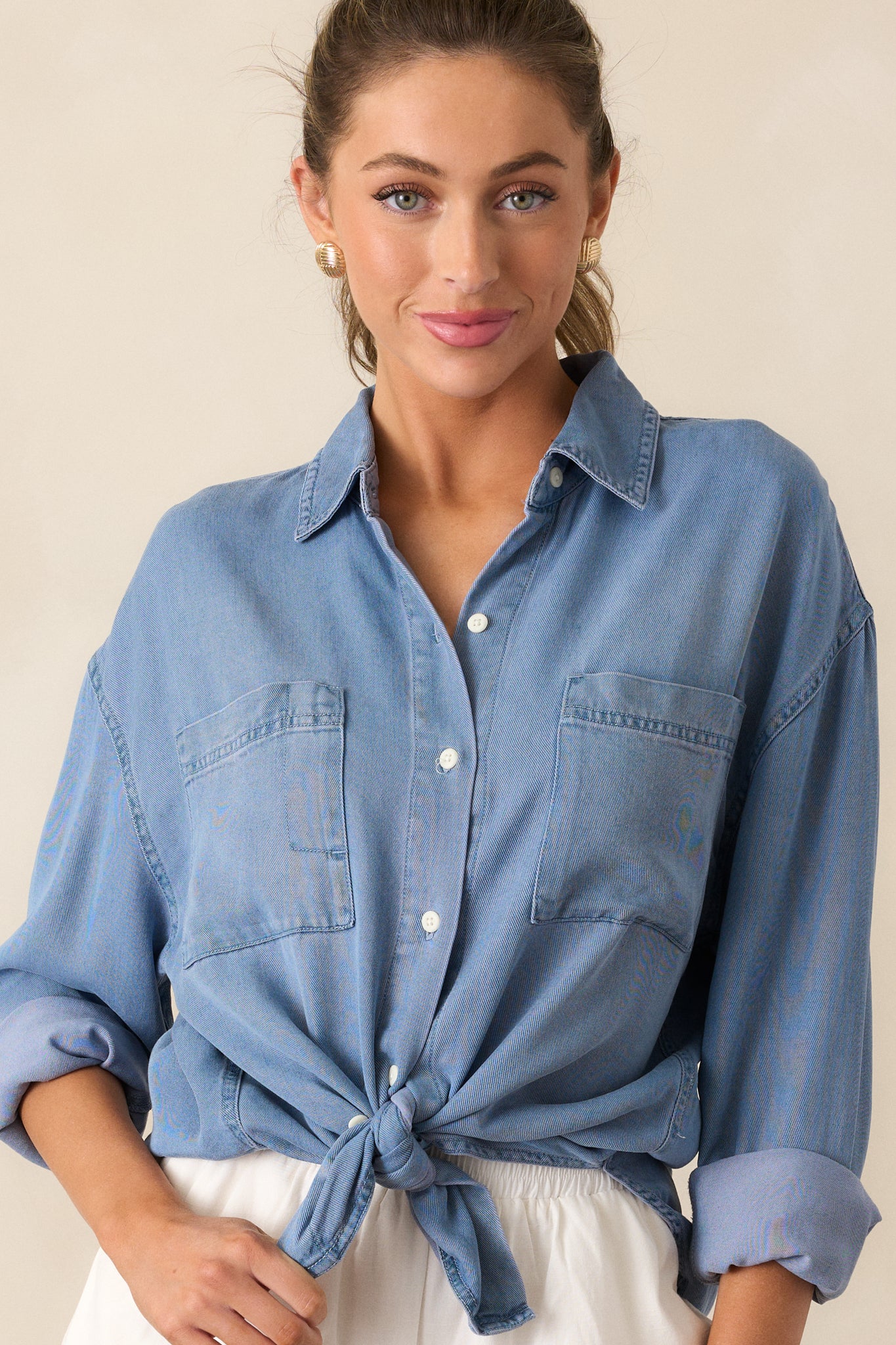 Close-up of the drop cut style and chest pockets on the chambray top