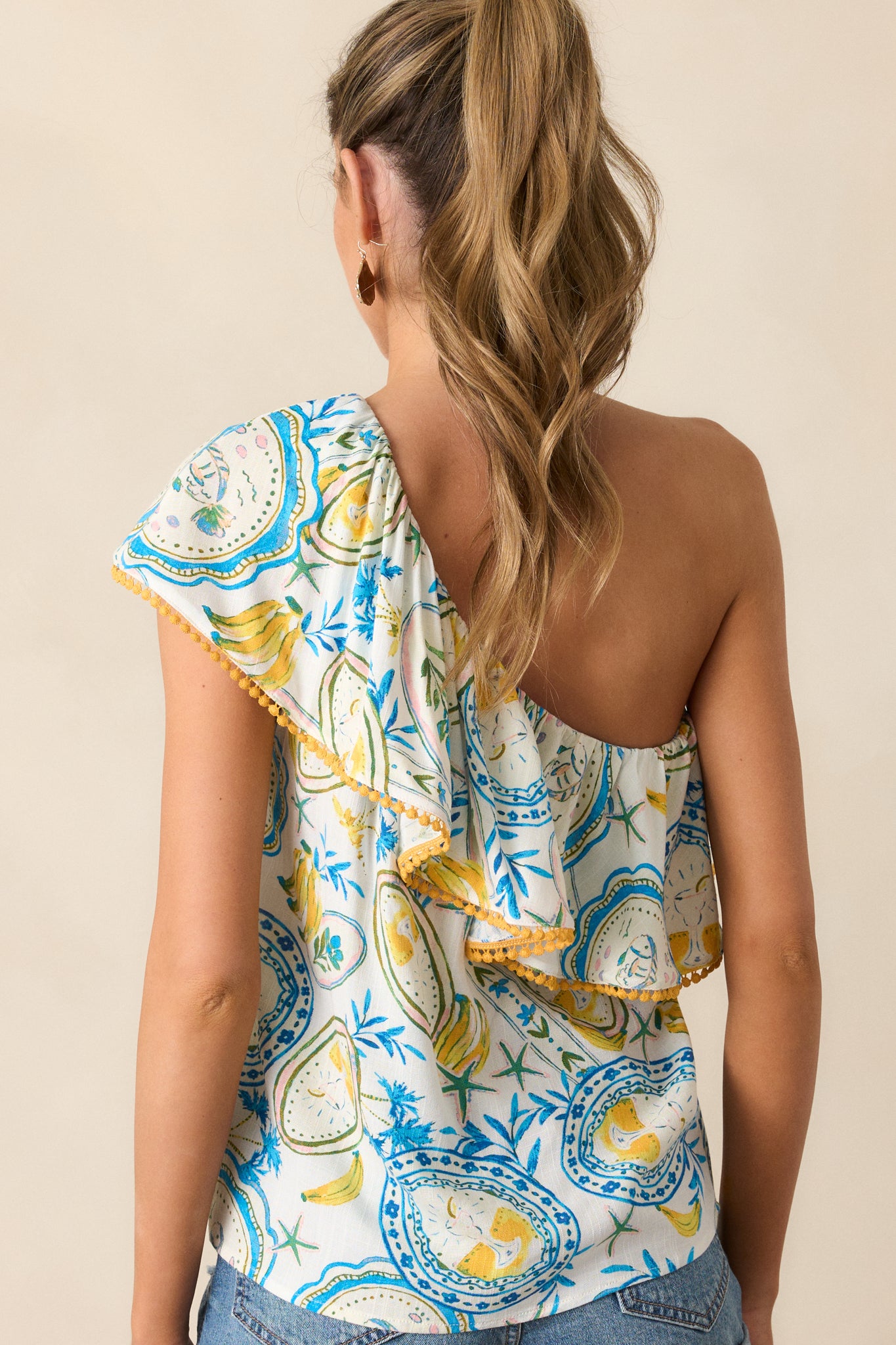 A back view of the ivory top displaying the continuation of the tropical print and its relaxed fit design.