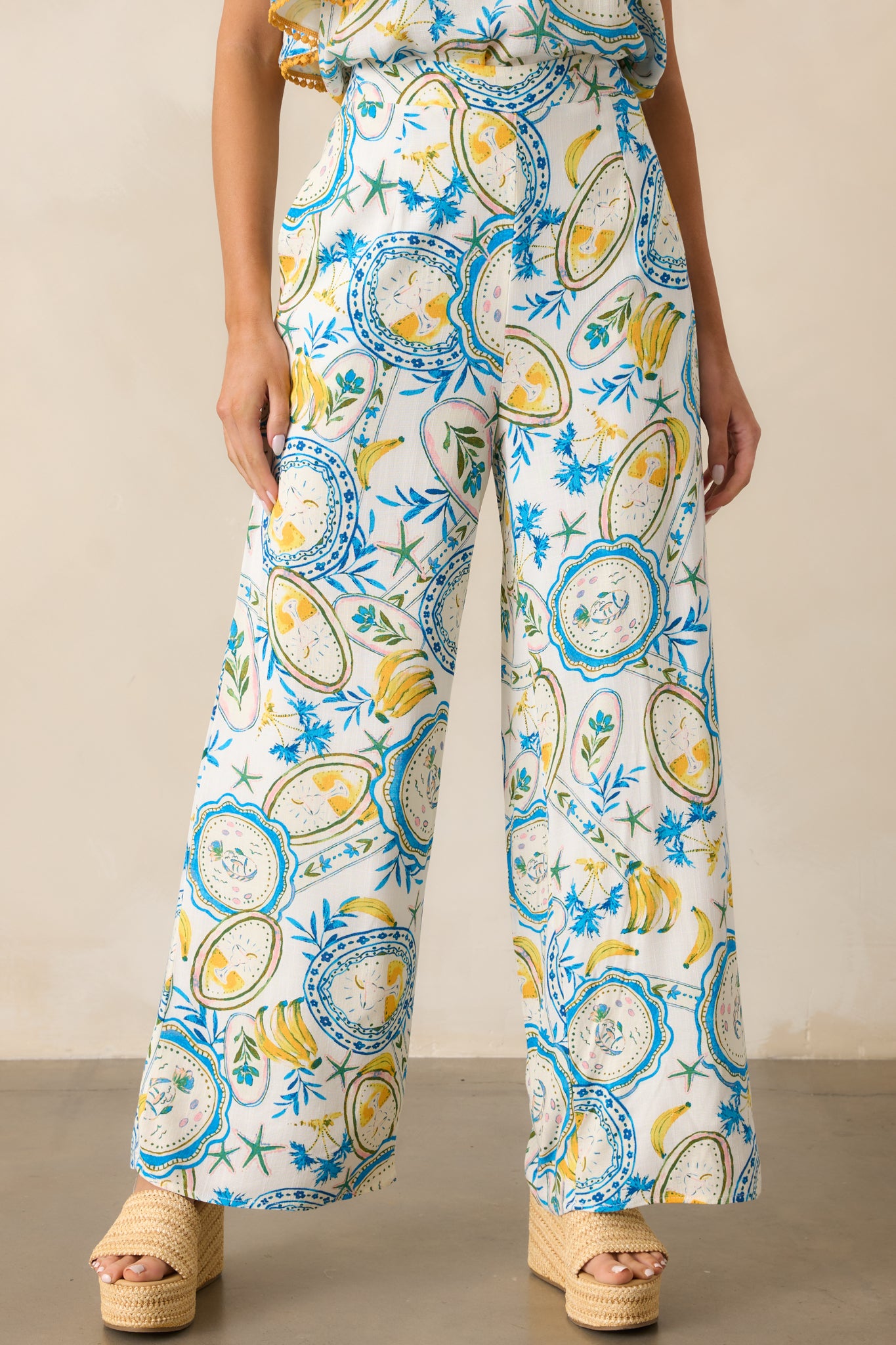 A closer look at the elastic back waistband and tropical print on the ivory pants.