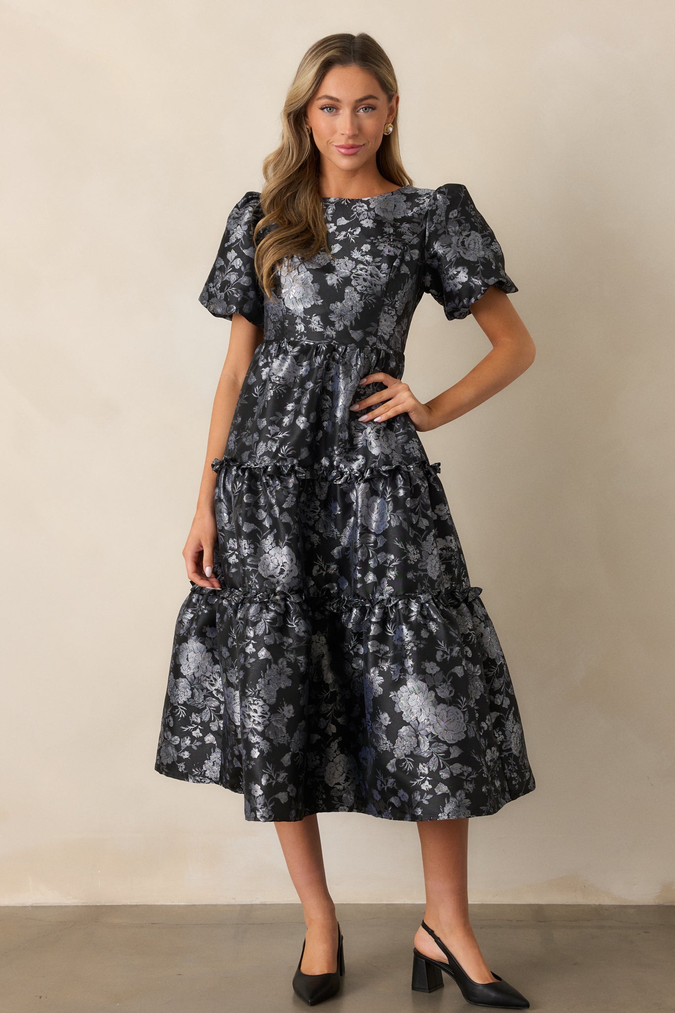 A full-length shot emphasizing the cascading tiers of the ruffle-hem skirt and the contrast between the silver floral pattern and the black fabric.