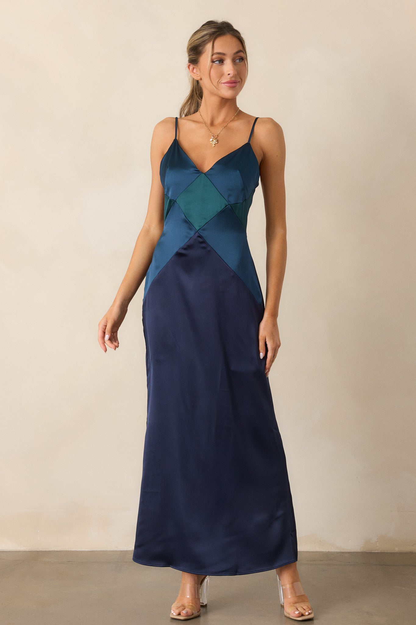 A full view of the dress emphasizing its flattering v-neckline, softly draped fabric, and the unique geometric detailing.