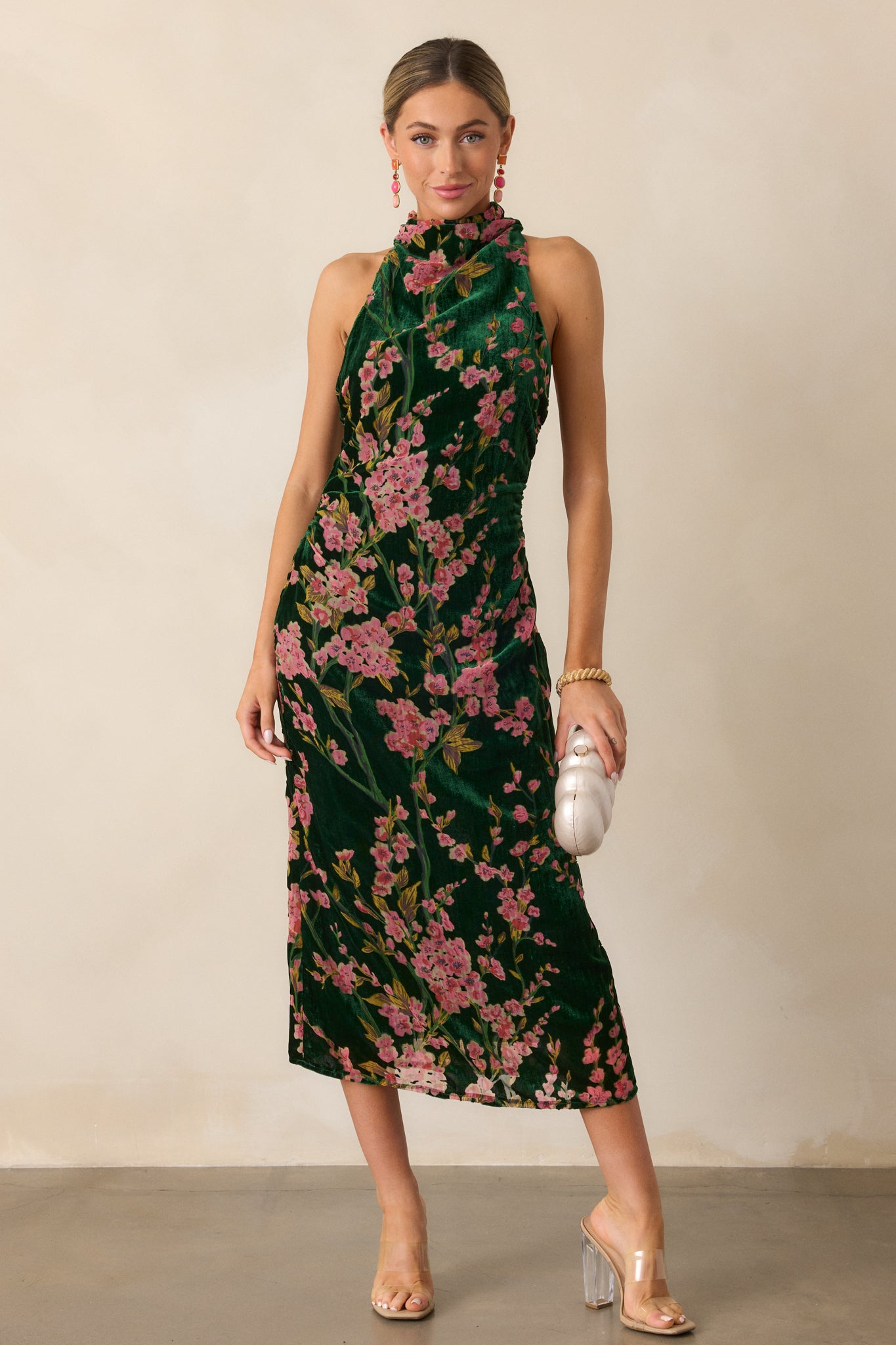  A full-length perspective focusing on the buttoned halter back and the soft, flowing silhouette of the maxi-length skirt.