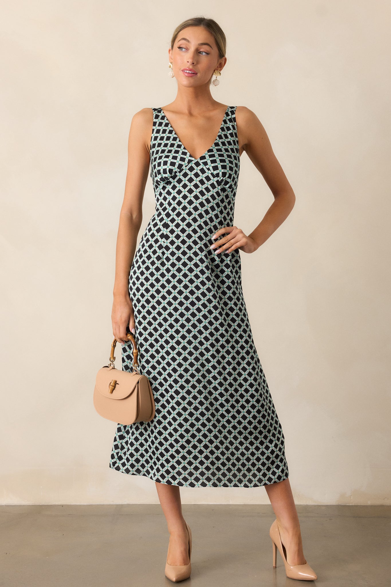 Front-facing full-body image highlighting the geometric print and the flowing midi-length silhouette of the black dress.