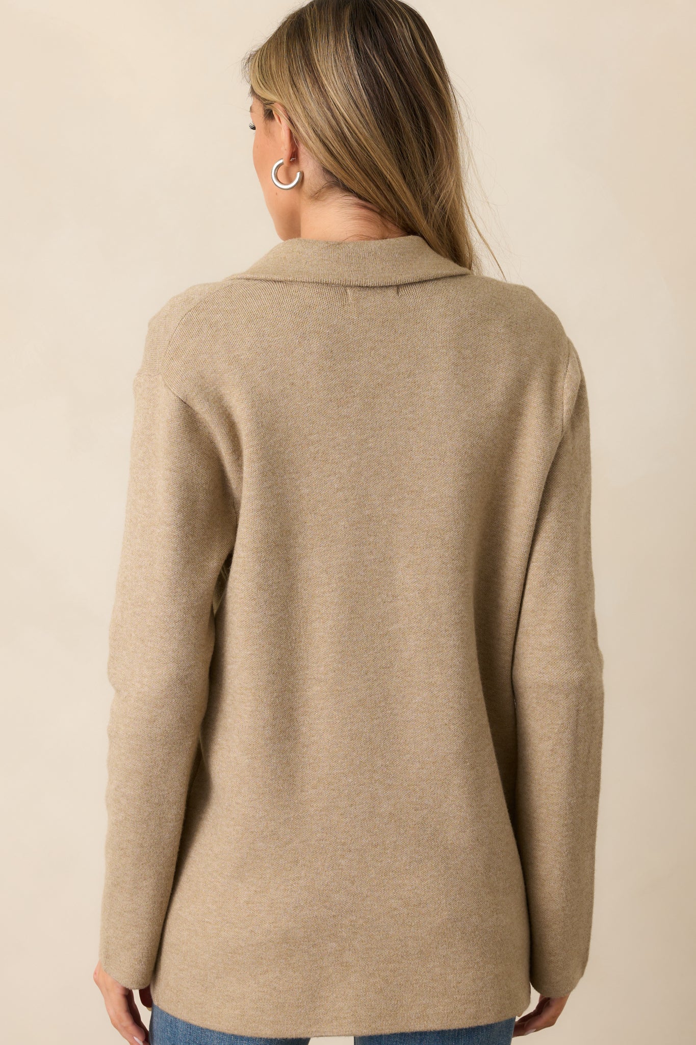 The back of the oatmeal heather blazer, featuring a smooth knit finish and long sleeves that complete its polished look.