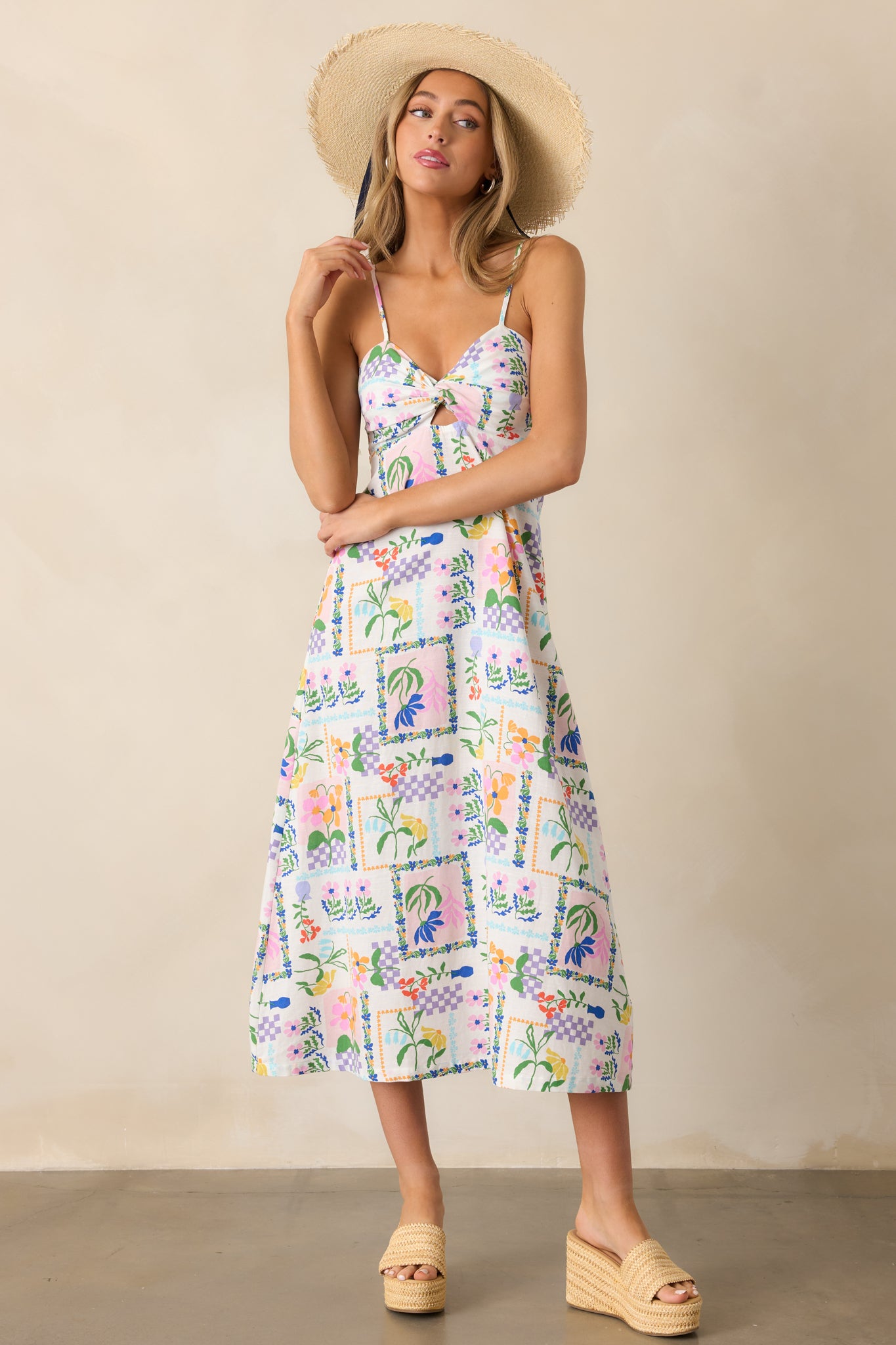 Full-length view of the ivory dress, emphasizing its smocked back, adjustable straps, and colorful picnic print.