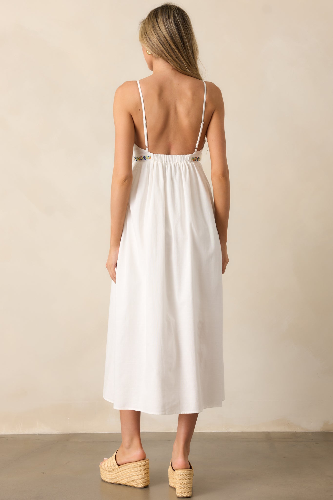 A back view of the ivory dress, showcasing its elastic insert at the back of the bust and adjustable spaghetti straps.