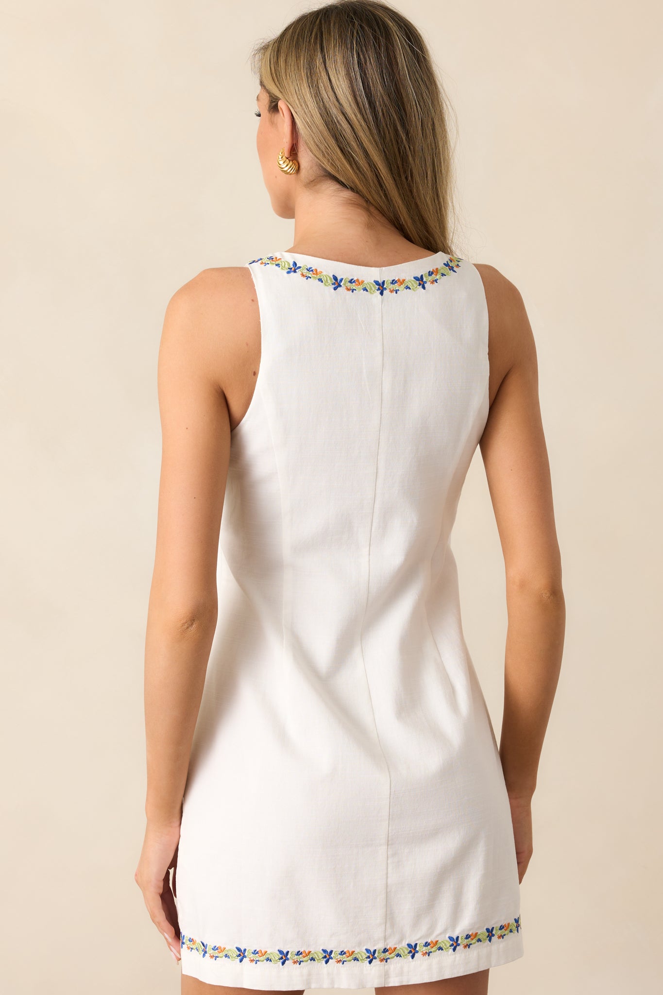 A back view of the ivory mini dress, showcasing its button front design and flowing silhouette.