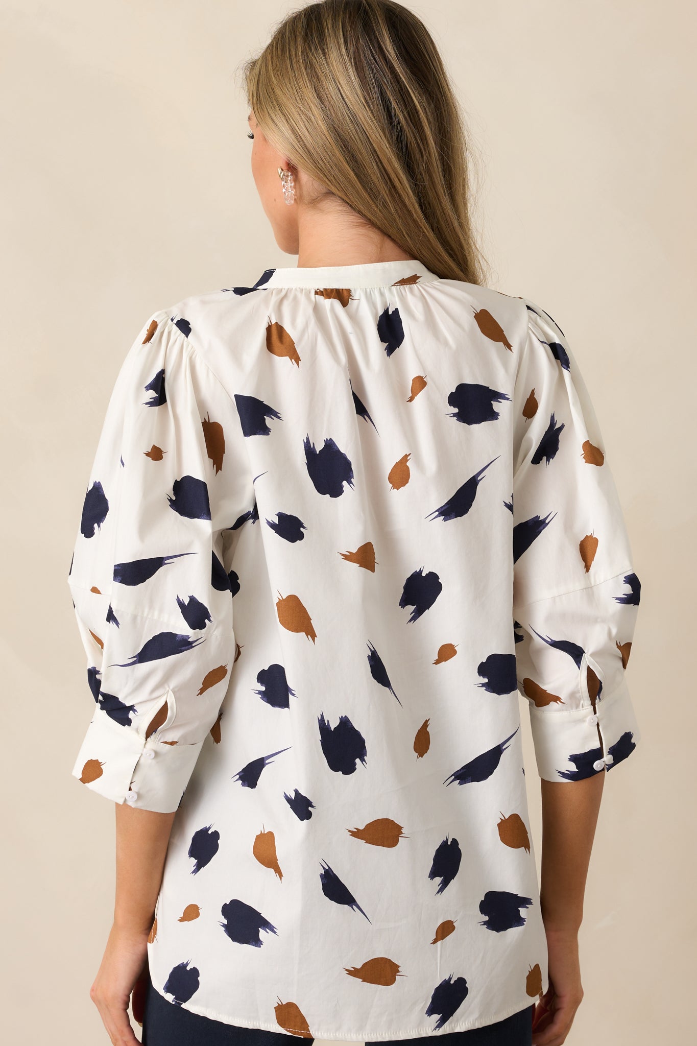 Back view of the ivory blouse displaying the relaxed fit and flow of the brush stroke print.