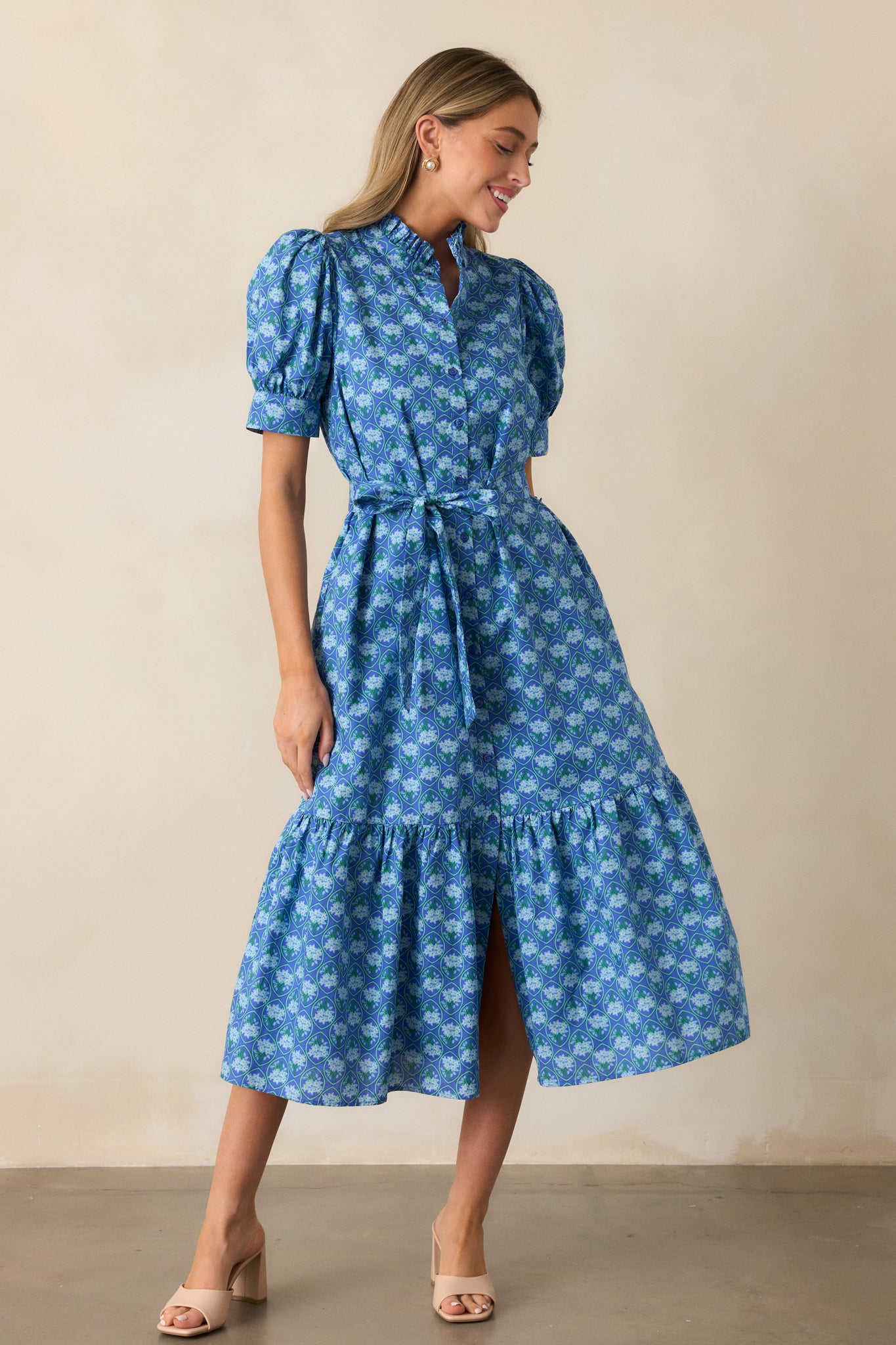 The blue dress shown in a full view, emphasizing the button front design, high ruffle collar, and petite floral pattern.