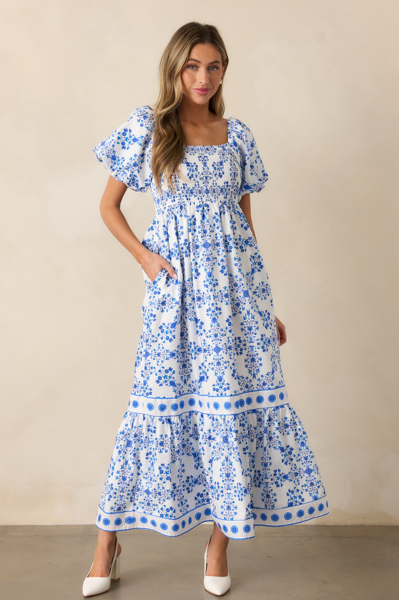 The royal blue maxi dress shown in a full-body shot, focusing on the intricate floral design, relaxed skirt, and short puff sleeves.