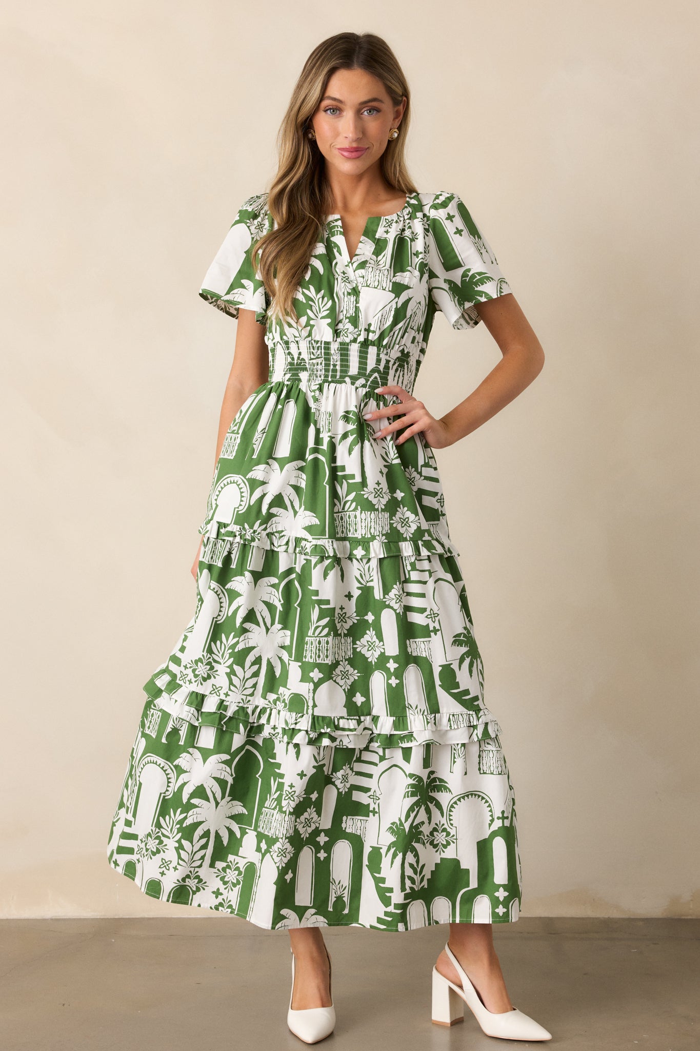 A full-length display of the green dress with a notch neckline, short sleeves, and a relaxed, tiered skirt.