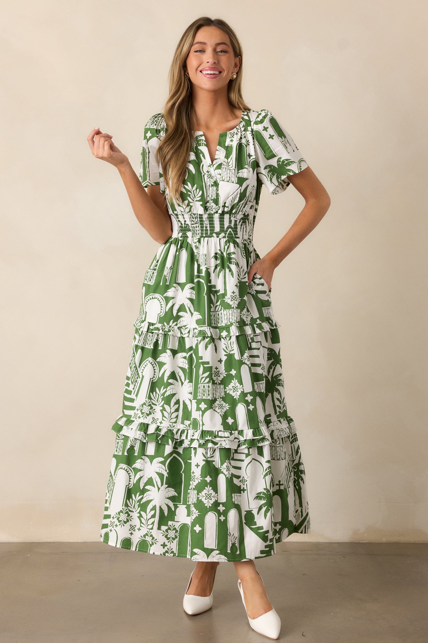 The green dress in a full-length photo, focusing on the relaxed tiered skirt and beautiful tropical palm print.