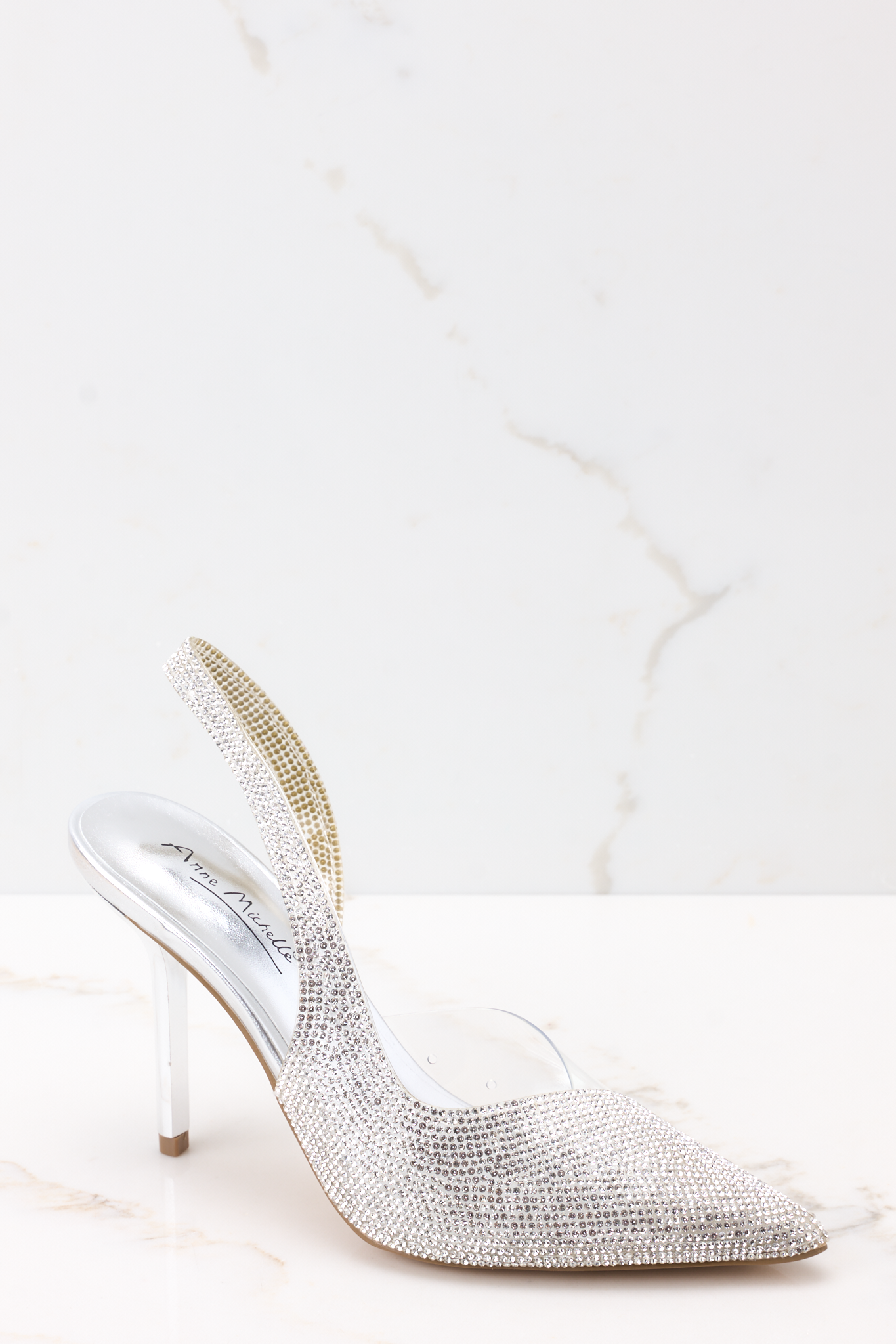 Premium Photo | A silver high heel shoe with a silver design on the bottom.