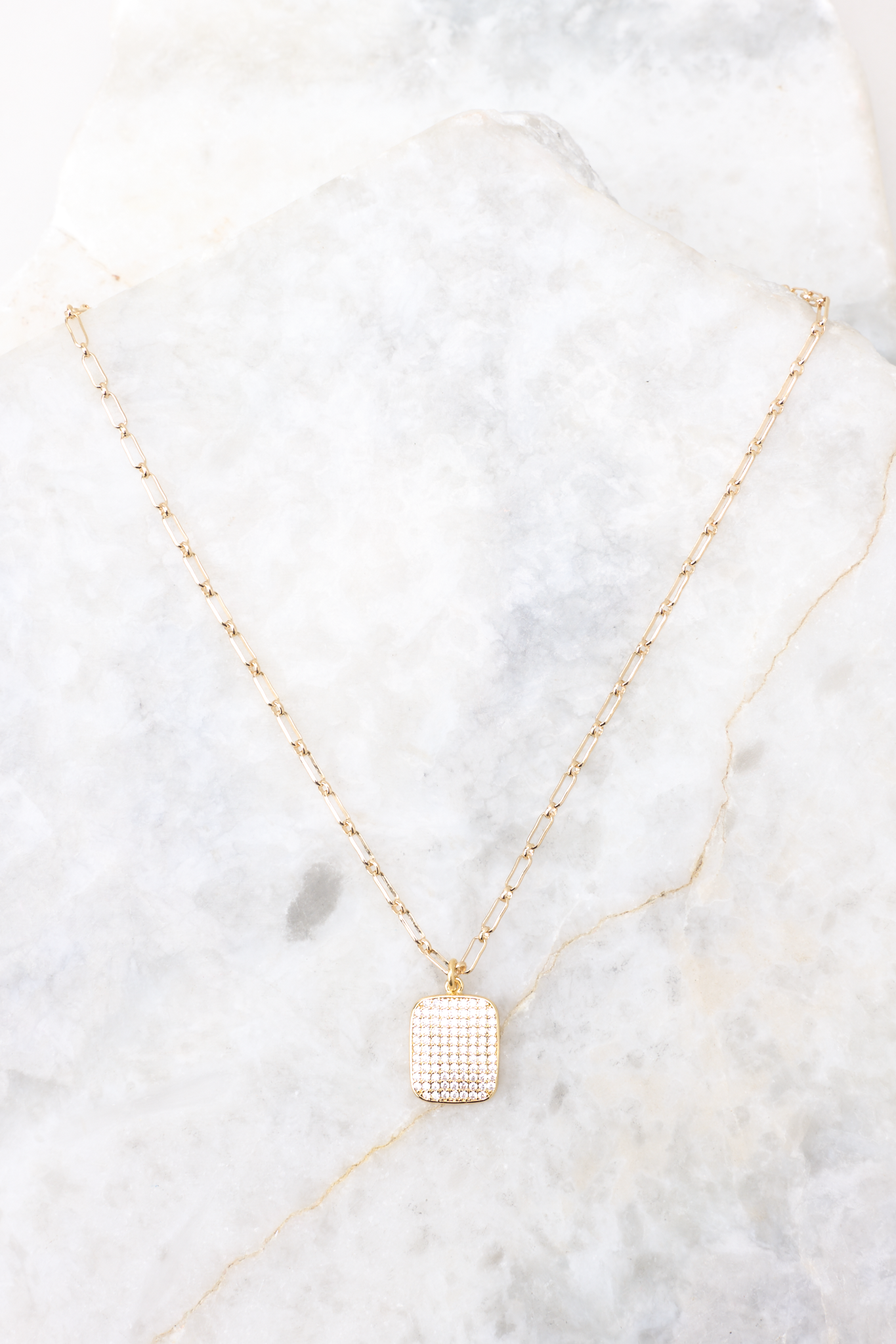 This necklace features a gold chain, a square rhinestone pendant, and a lobster clasp.