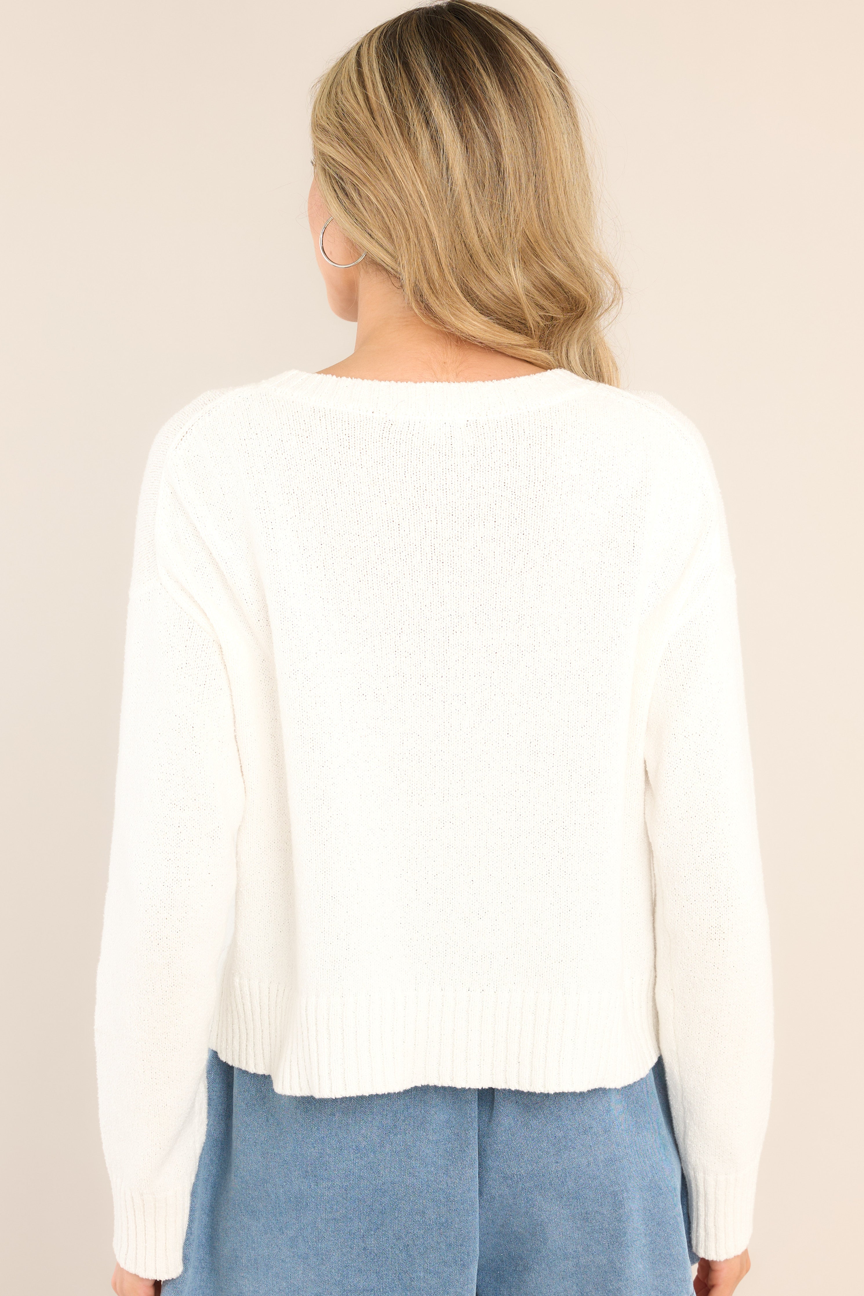 Back view of  this sweater that features a ribbed crew neckline, varsity style wording across the chest, and ribbed cuffed long sleeves.