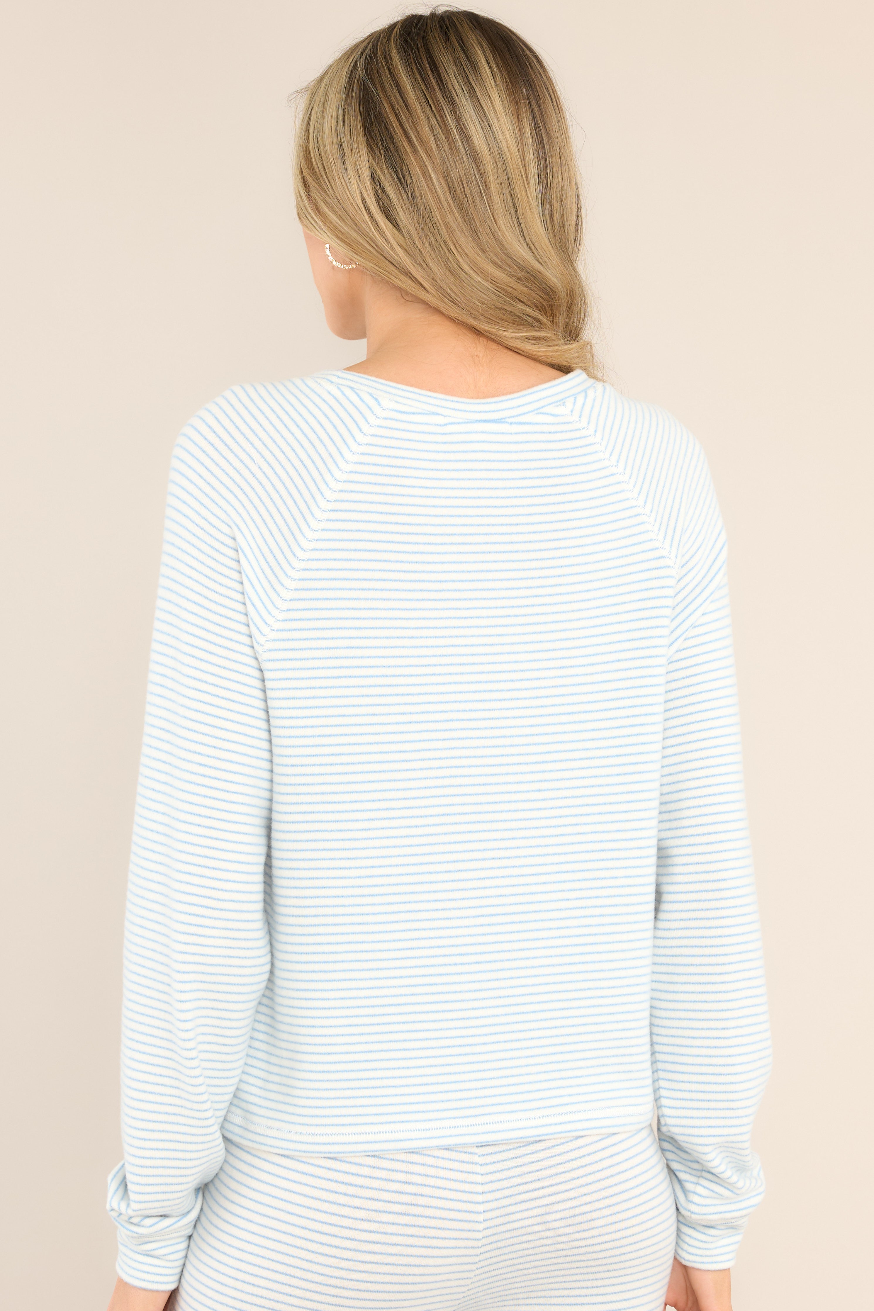 Back view of this Z Supply white and blue, horizontally thin striped lounge top with a crew neck, soft breathable material, and cuffed long sleeves.