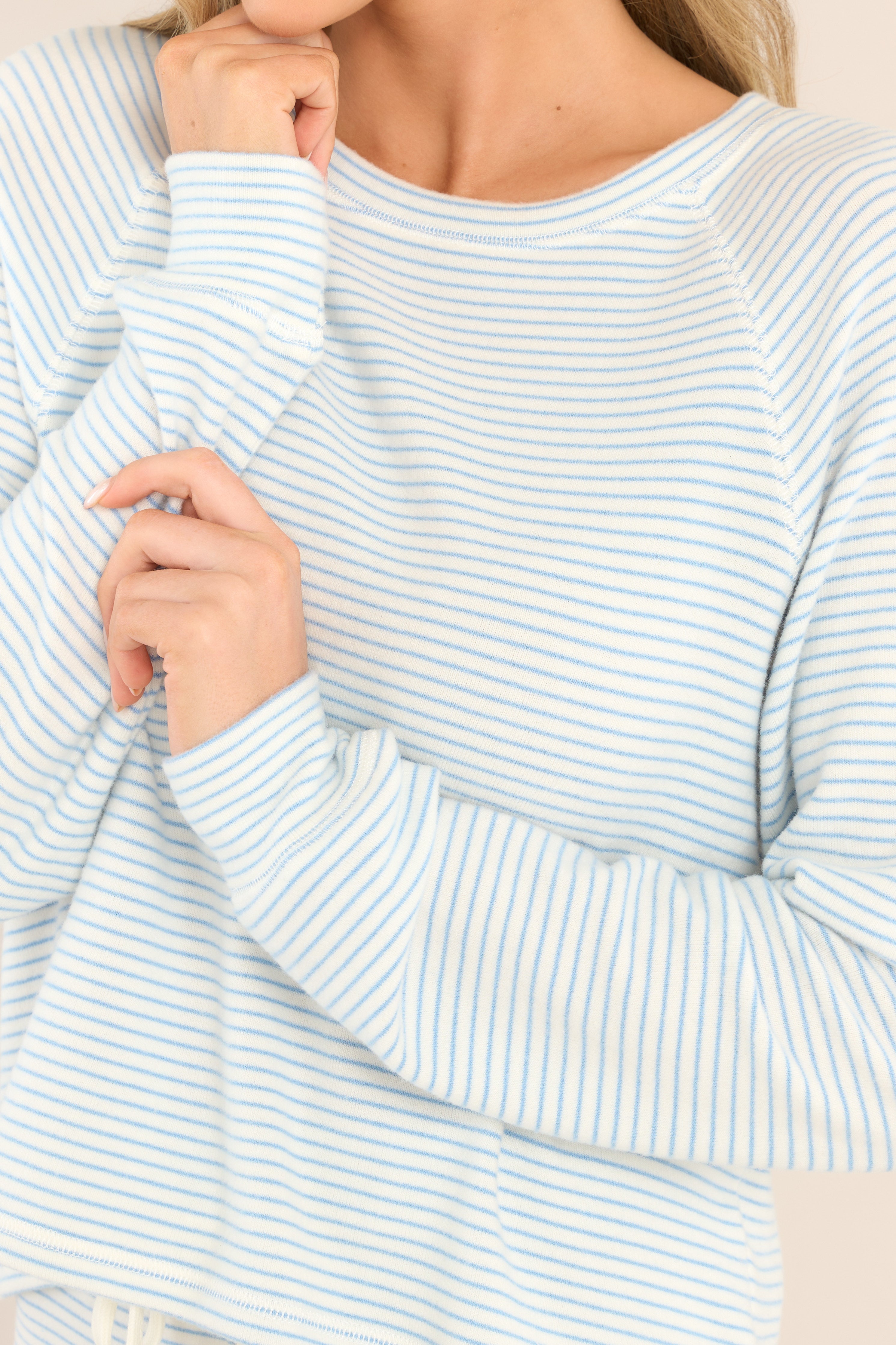 Detailed close up of this Z Supply white and blue, horizontally thin striped lounge top with a crew neck, soft breathable material, and cuffed long sleeves.