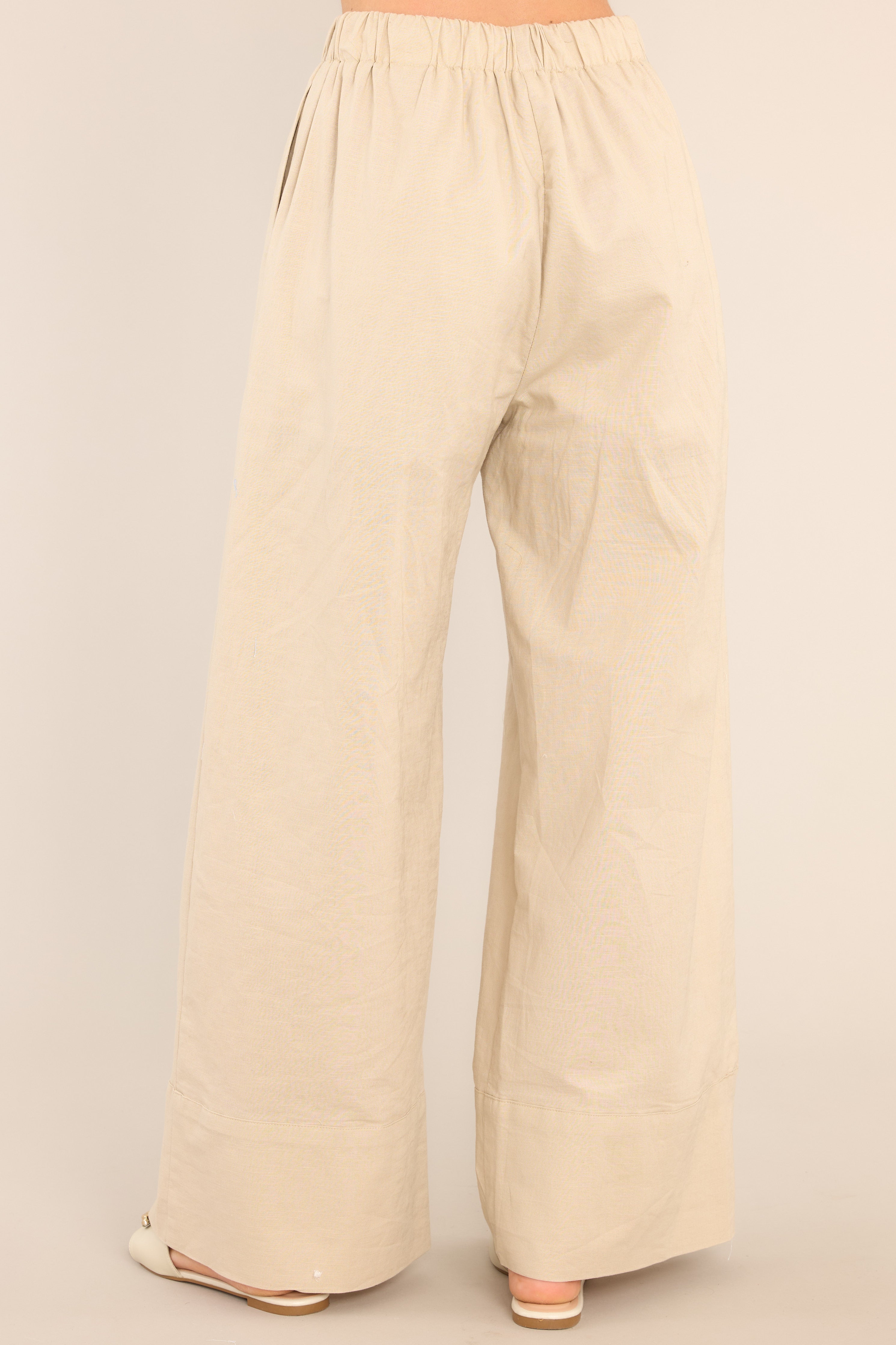 Back view of these pants that feature a high waisted design, an elastic waistband with a self-tie feature, functional pockets, and a thick ankle cuff.