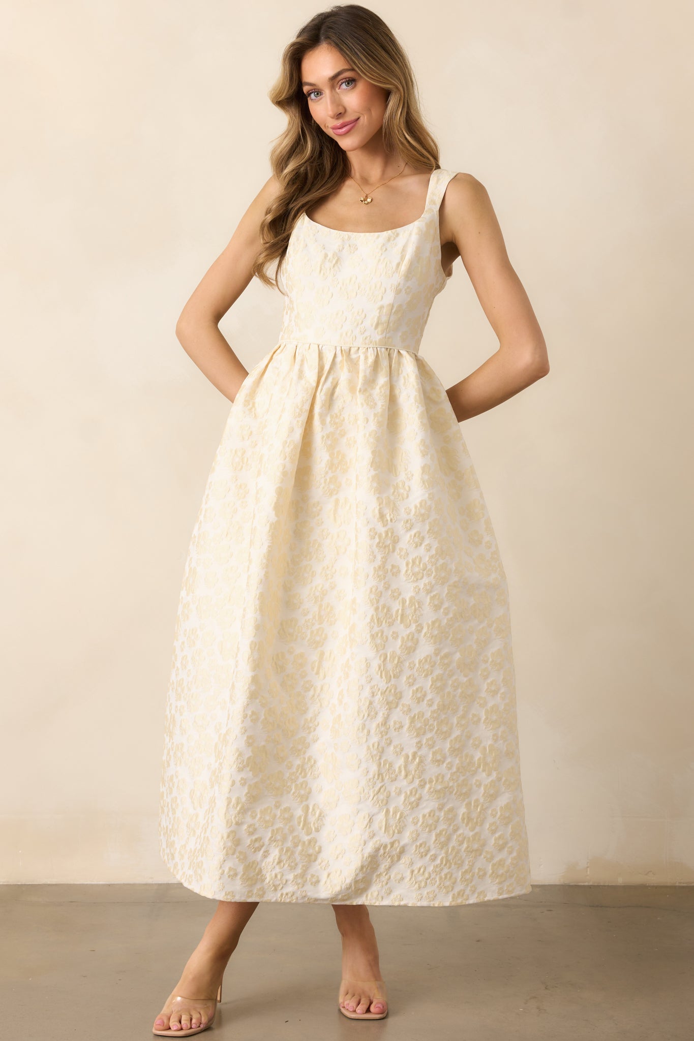 A butter yellow dress featuring a floral jacquard fabric, a scoop neckline, and a structured skirt for an elegant silhouette.