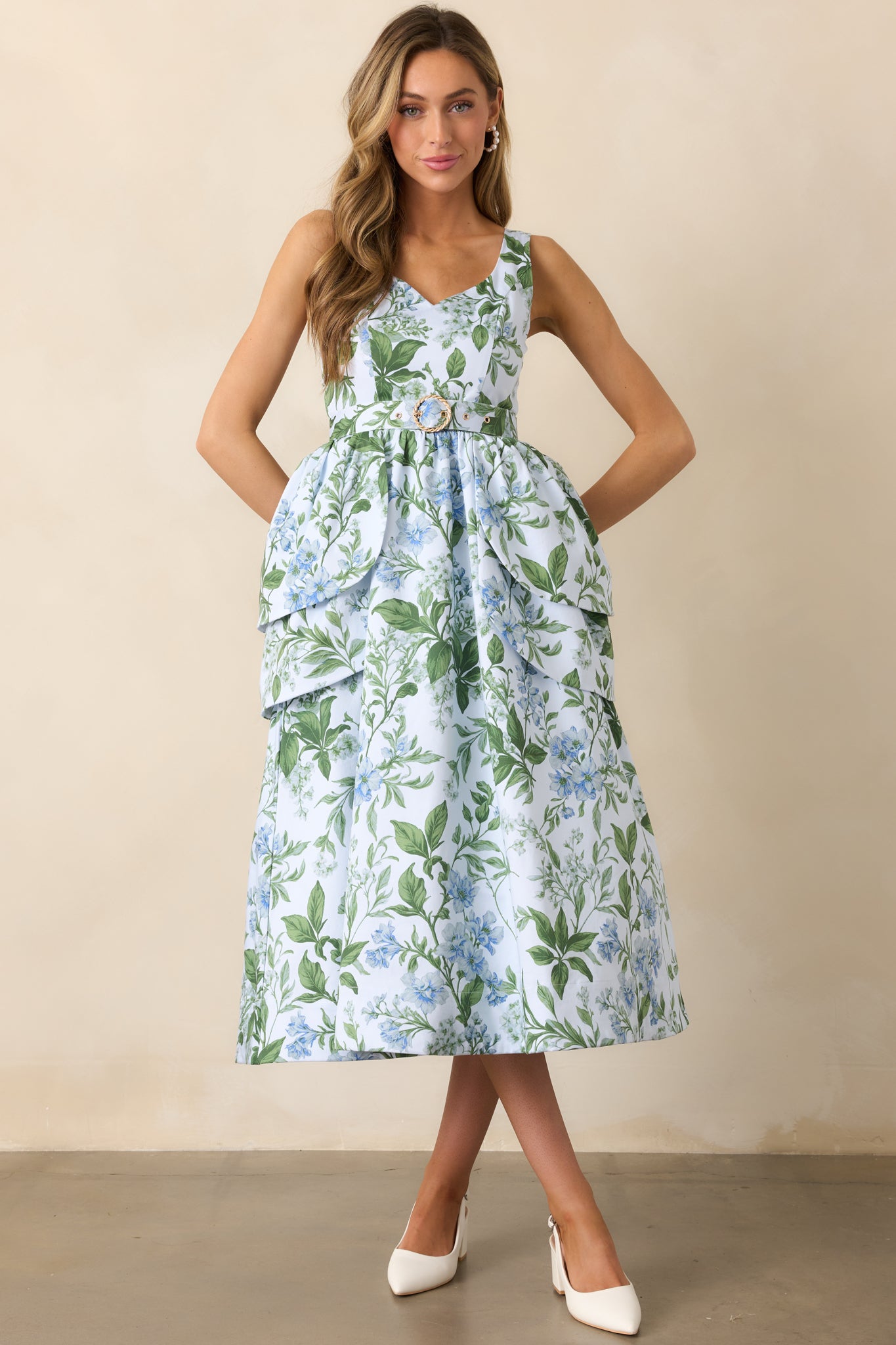 A stunning blue maxi dress featuring a flattering V-neckline, sleeveless design, and petal-shaped tiered overskirt panels for a whimsical touch.