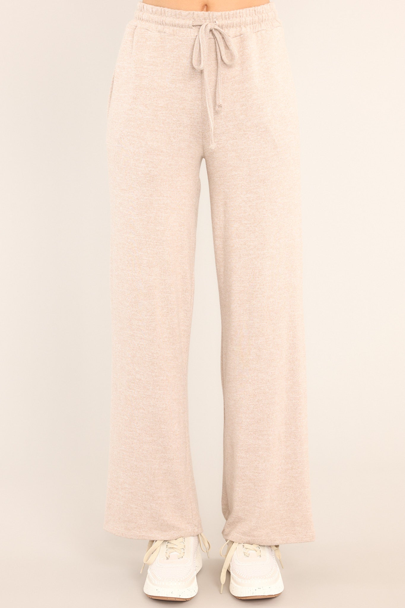 Full front view of these tan lounge pants that feature an elastic waistband with a self-tie drawstring, pockets, and a wide leg.