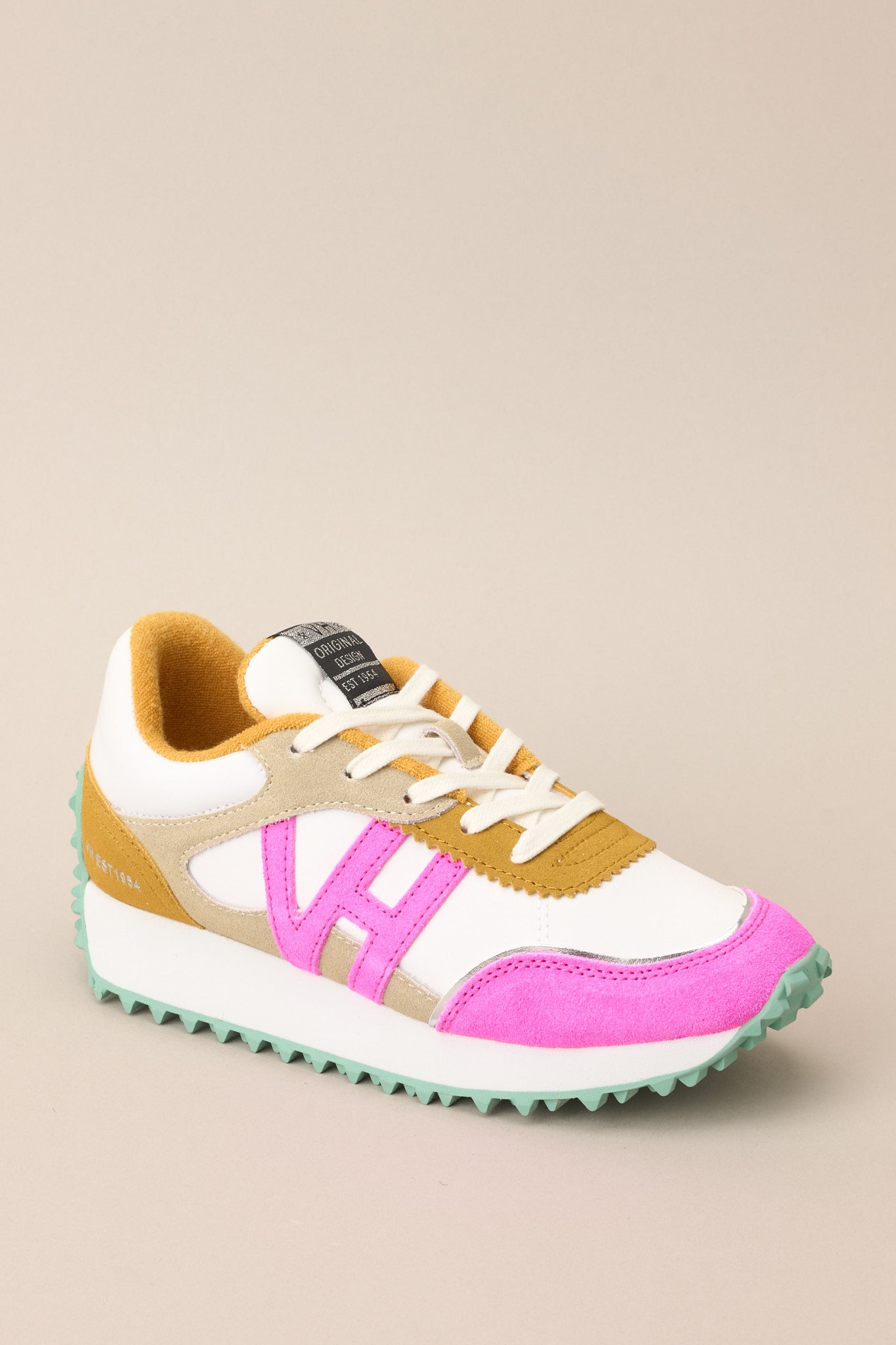 Angled outer-side view of these sneakers that feature a rounded toe, functional laces, pops of color, a slight platform, and a heavily textured sole.